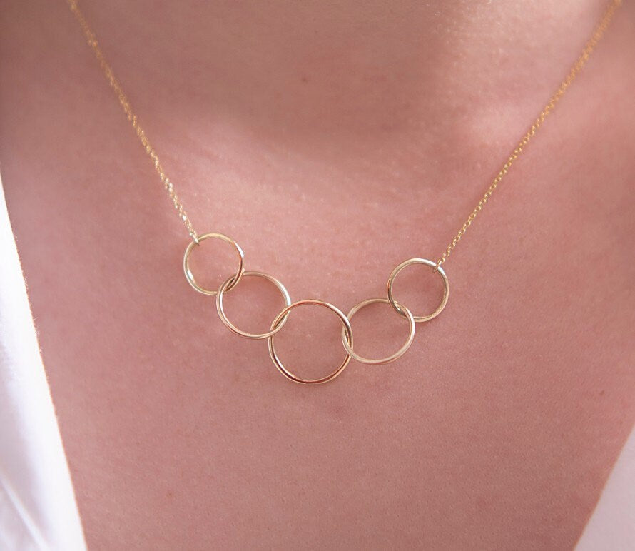 14k gold necklace with five interlocking circles for women worn by a model 