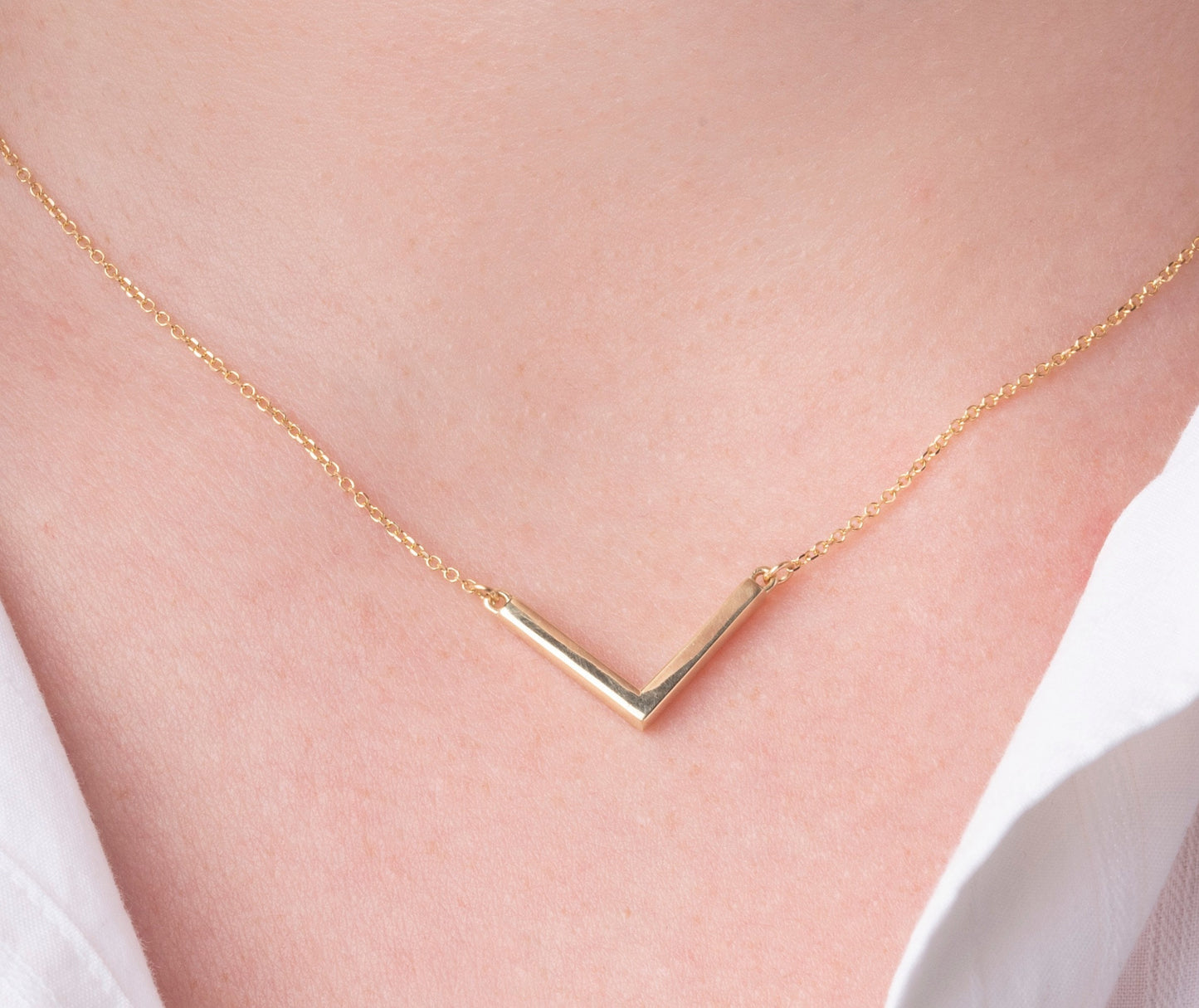 14k gold V shaped necklace for women worn by a model 