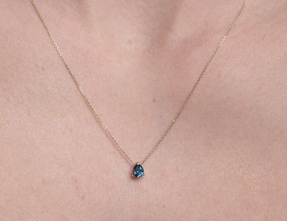 drop  blue aquamarine necklace in 14k white gold worn by a model 