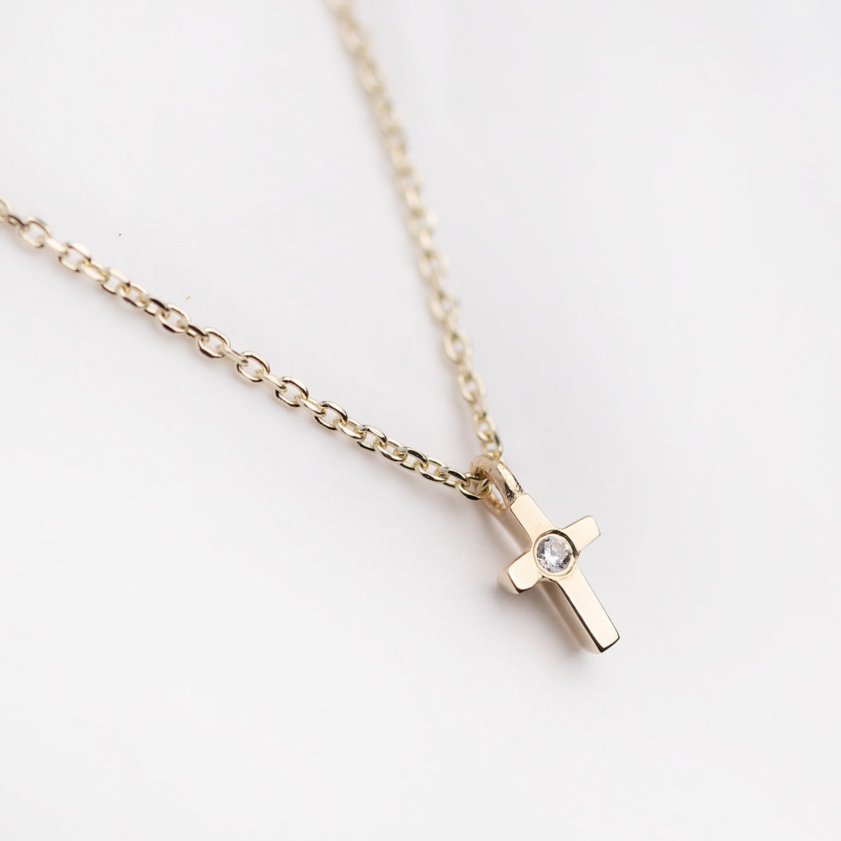 tiny diamond cross necklace in 14k yellow gold