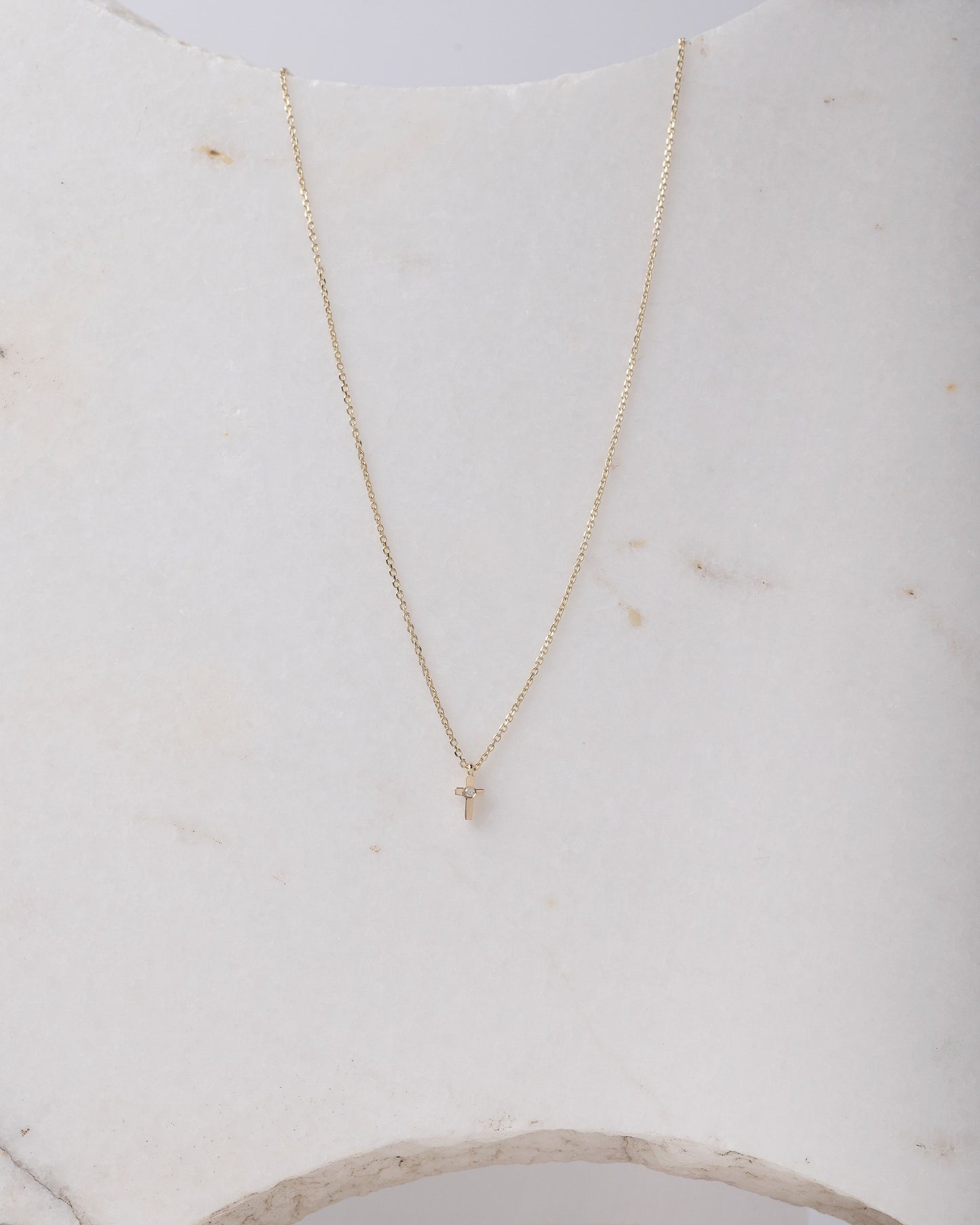 tiny diamond cross necklace in 14k yellow gold