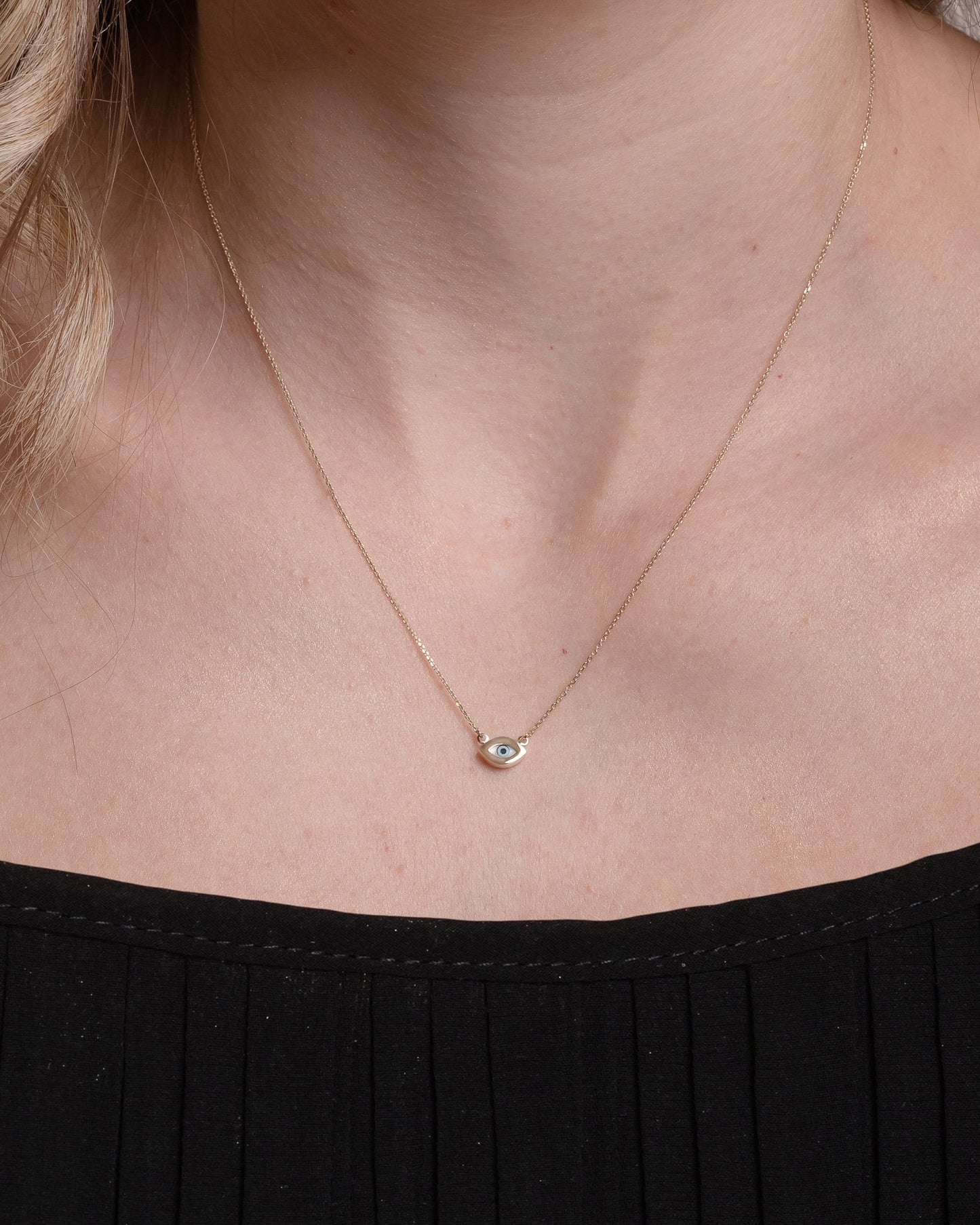 An oval-shaped evil eye necklace featuring mother of pearl, set in 14k gold for women.