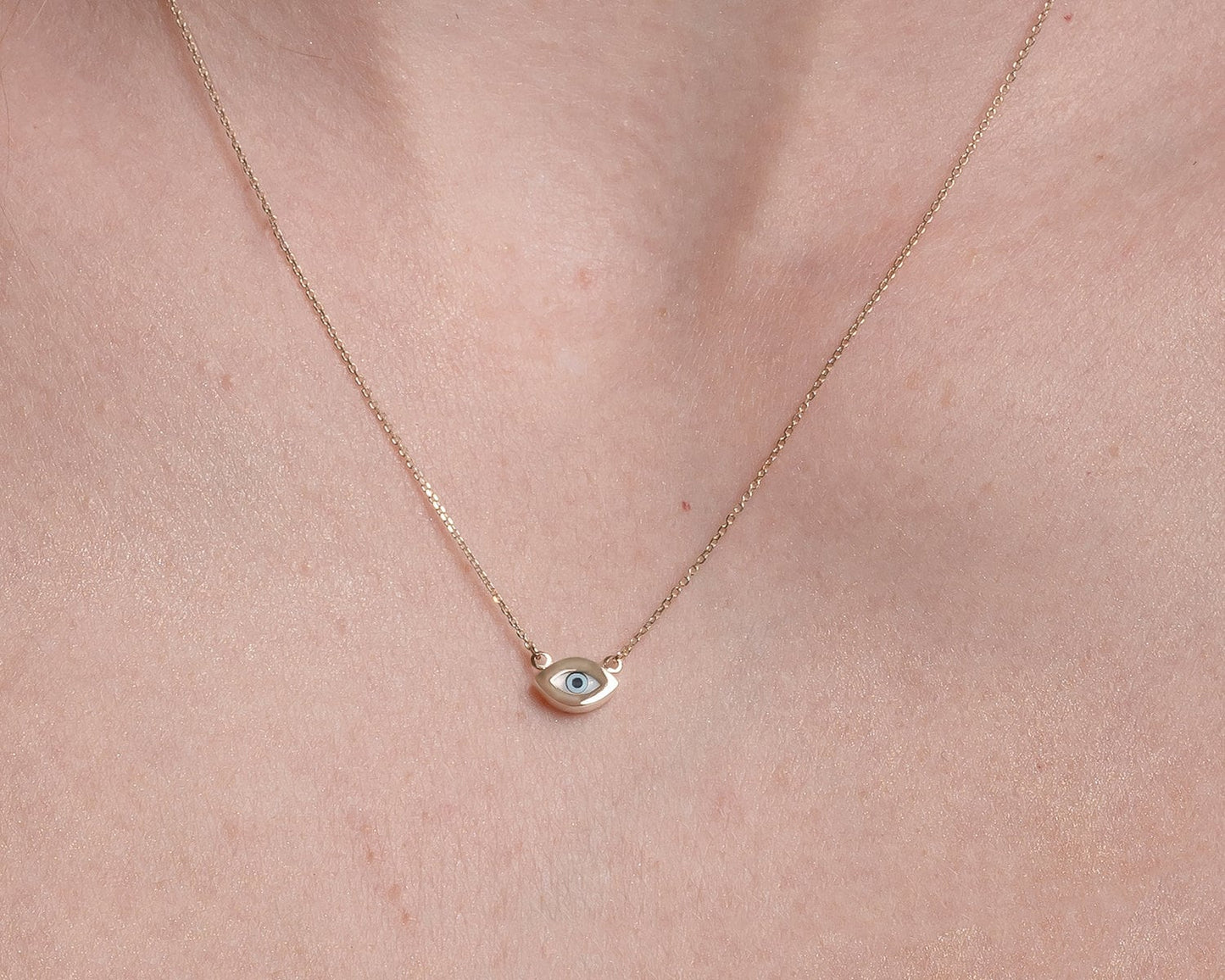 An oval-shaped evil eye necklace featuring mother of pearl, set in 14k gold for women.