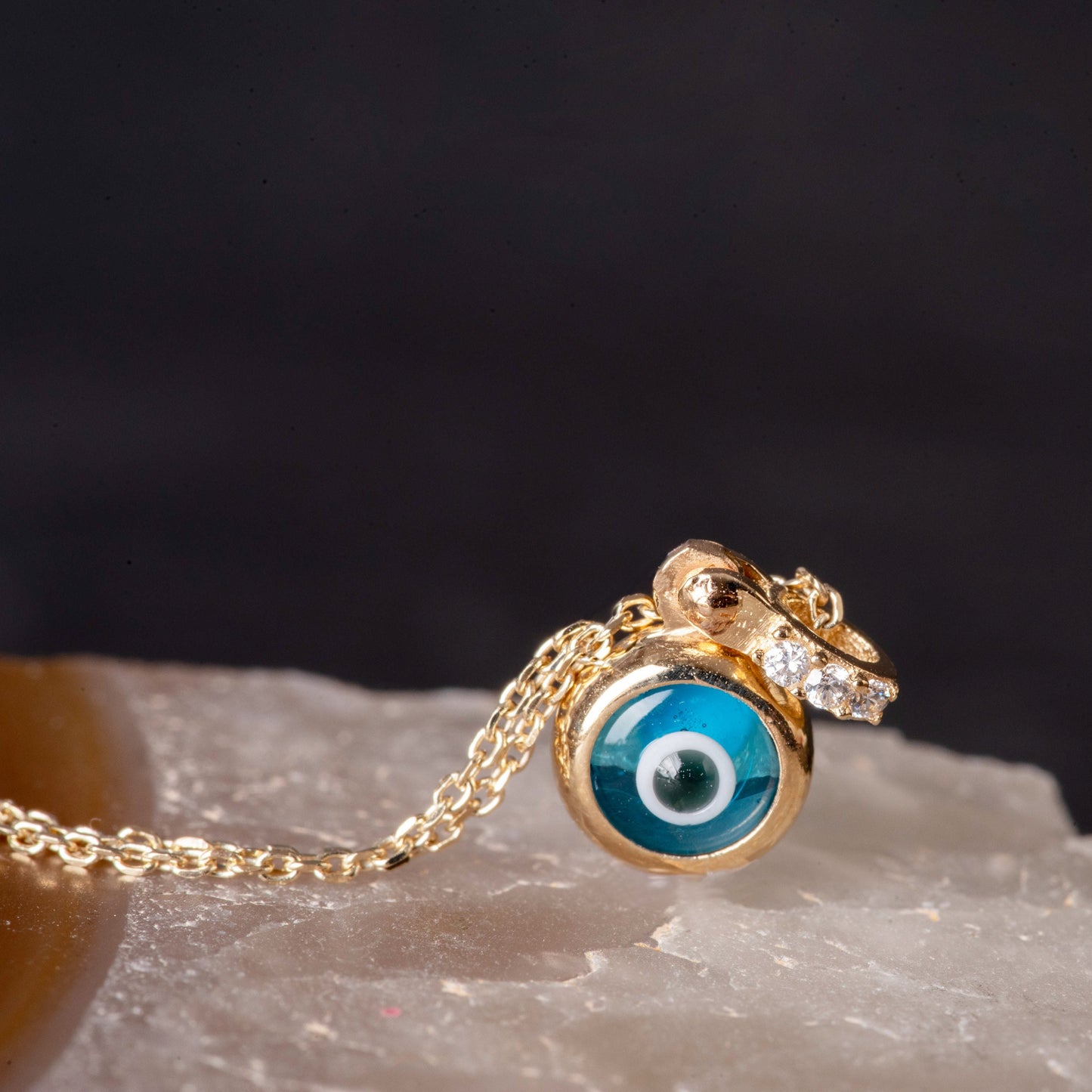 Murano glass evil eye necklace in 14k gold with cubic zirconia stones on the loop for women.