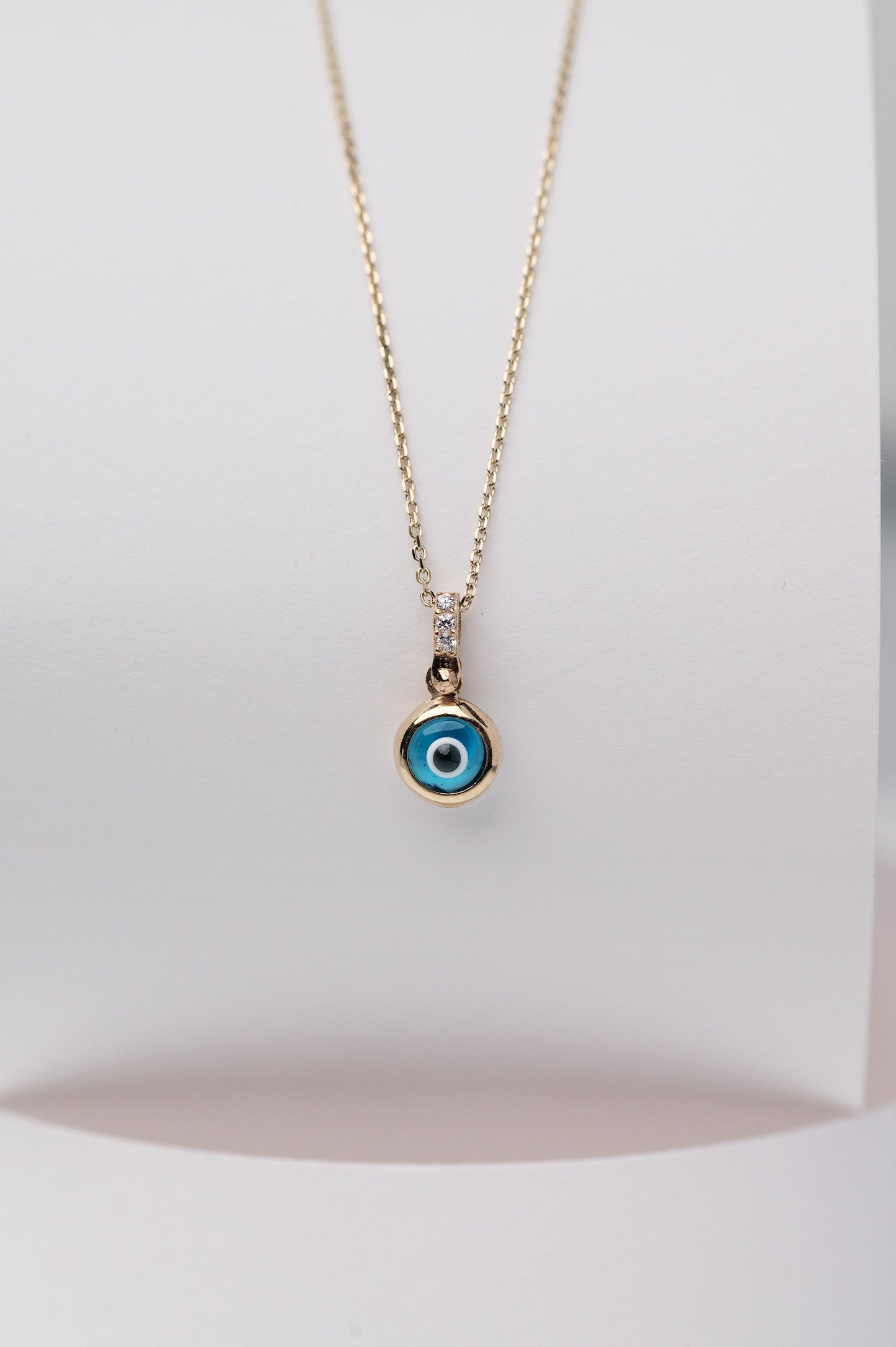 Murano glass evil eye necklace in 14k gold with cubic zirconia stones on the loop for women.