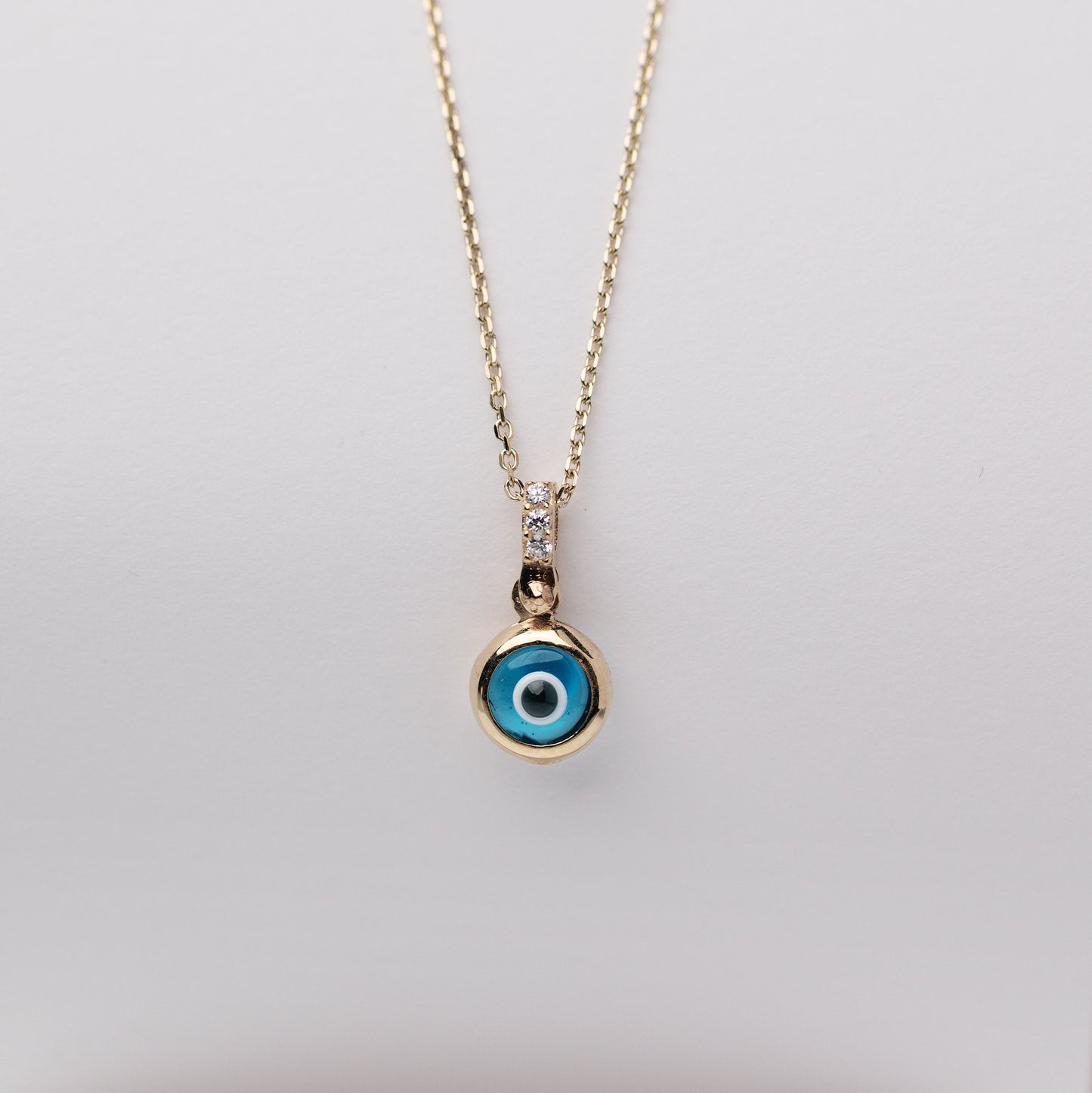 Murano glass evil eye necklace in 14k gold with cubic zirconia stones on the loop for women.