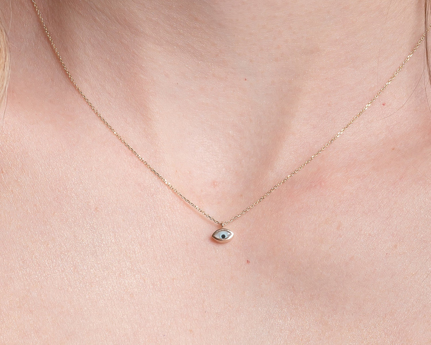 Tiny mother-of-pearl evil eye necklace in 14k gold for women.