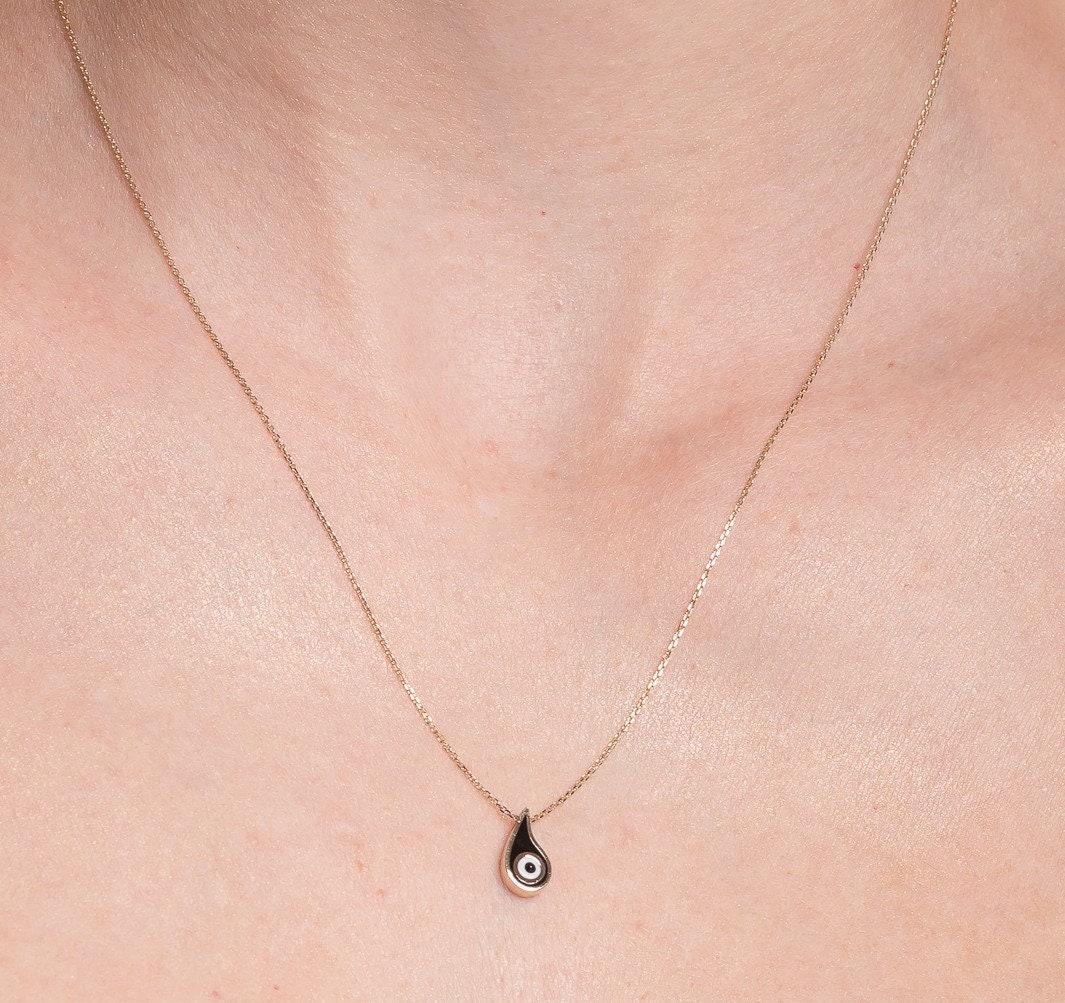 Evil Eye Paisley Necklace for women, crafted in 14k gold with black enamel detailing worn by a model 