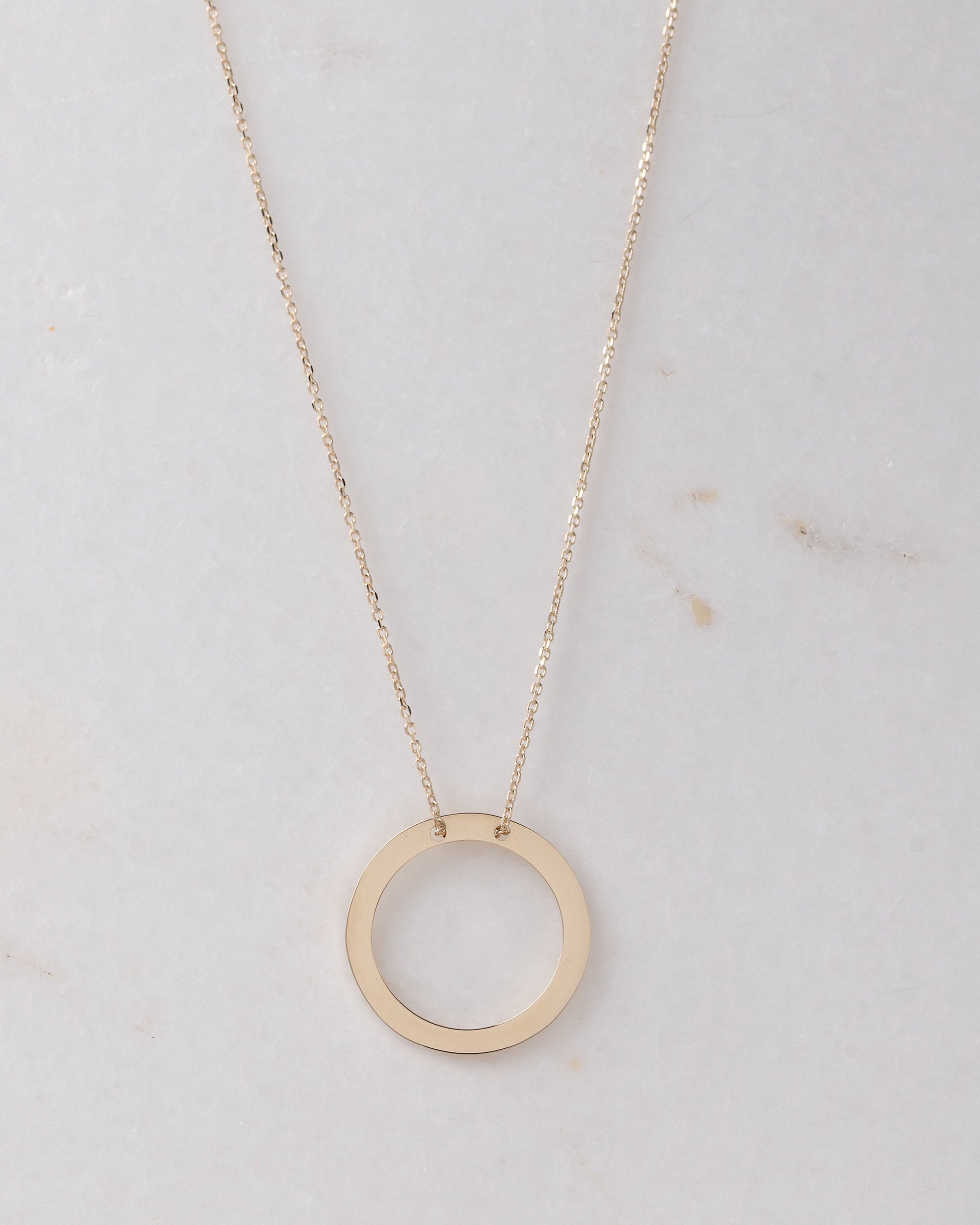 circle karma necklce in 14k gold half of the necklace is paved with cubic zirconia stones