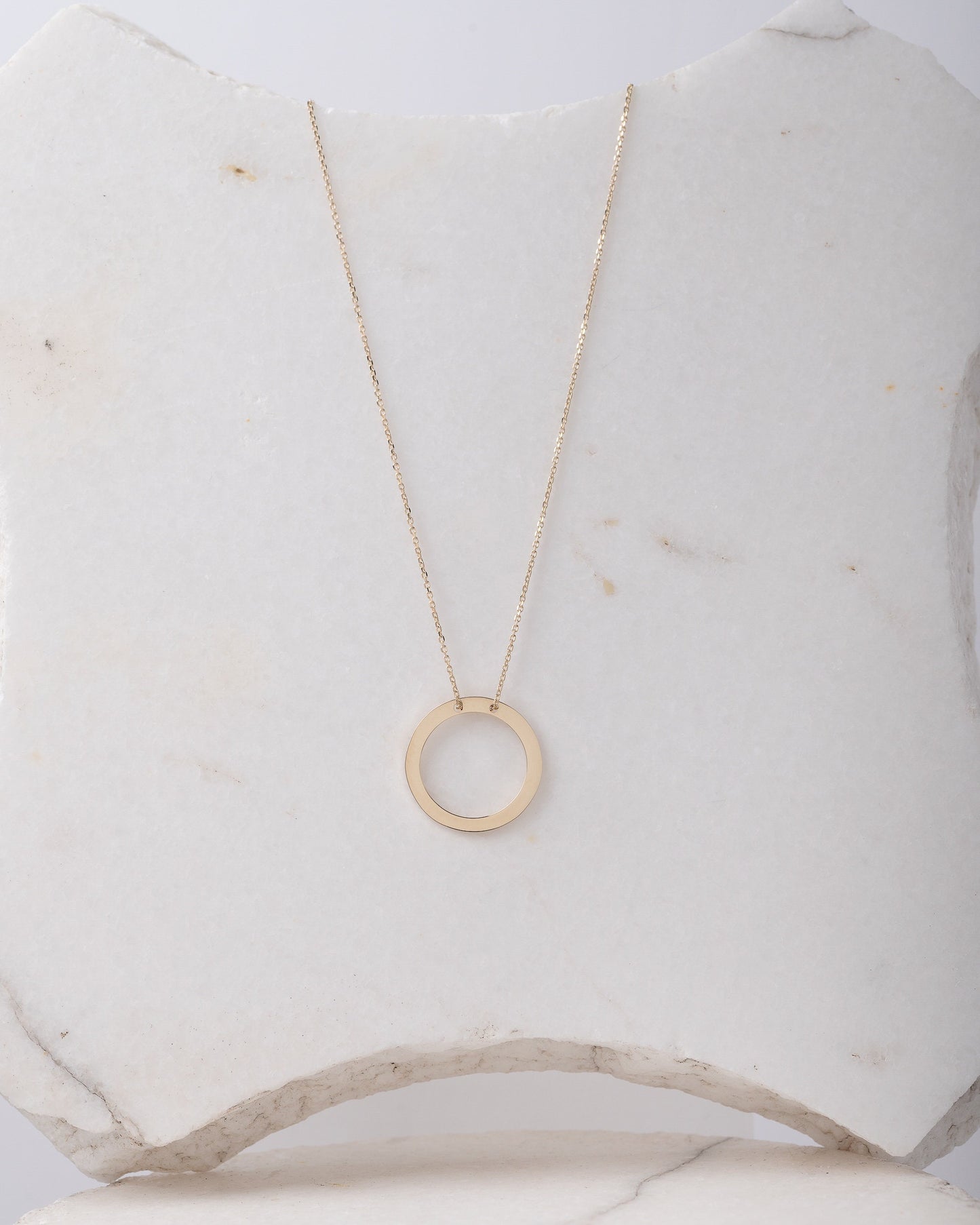 circle karma necklce in 14k gold half of the necklace is paved with cubic zirconia stones