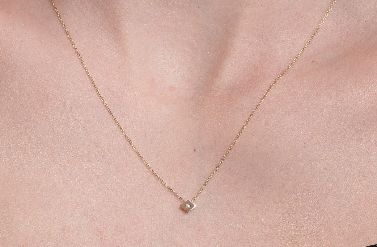 rhombus diamond necklace in 18k gold worn by a model 