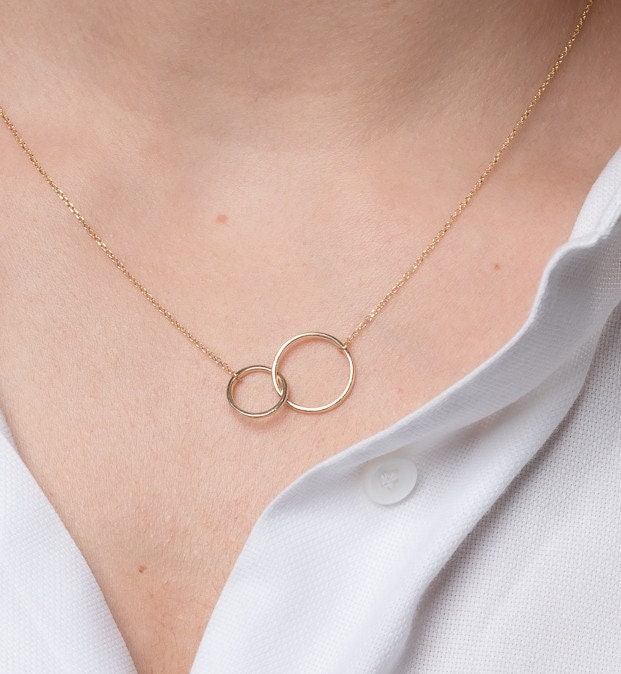 14k gold necklace with two interlocking circles worn by a model 