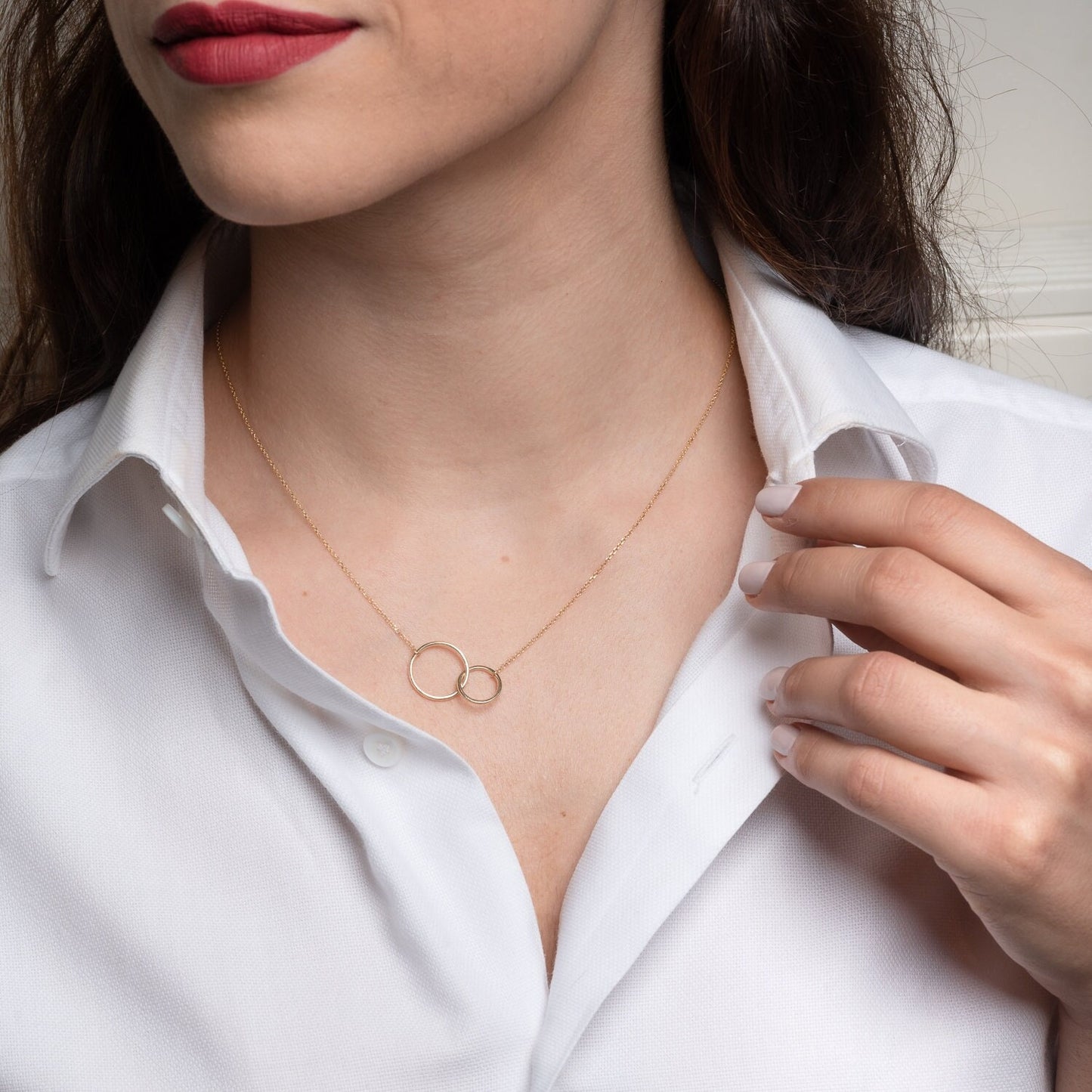 14k gold necklace with two interlocking circles worn by a model 