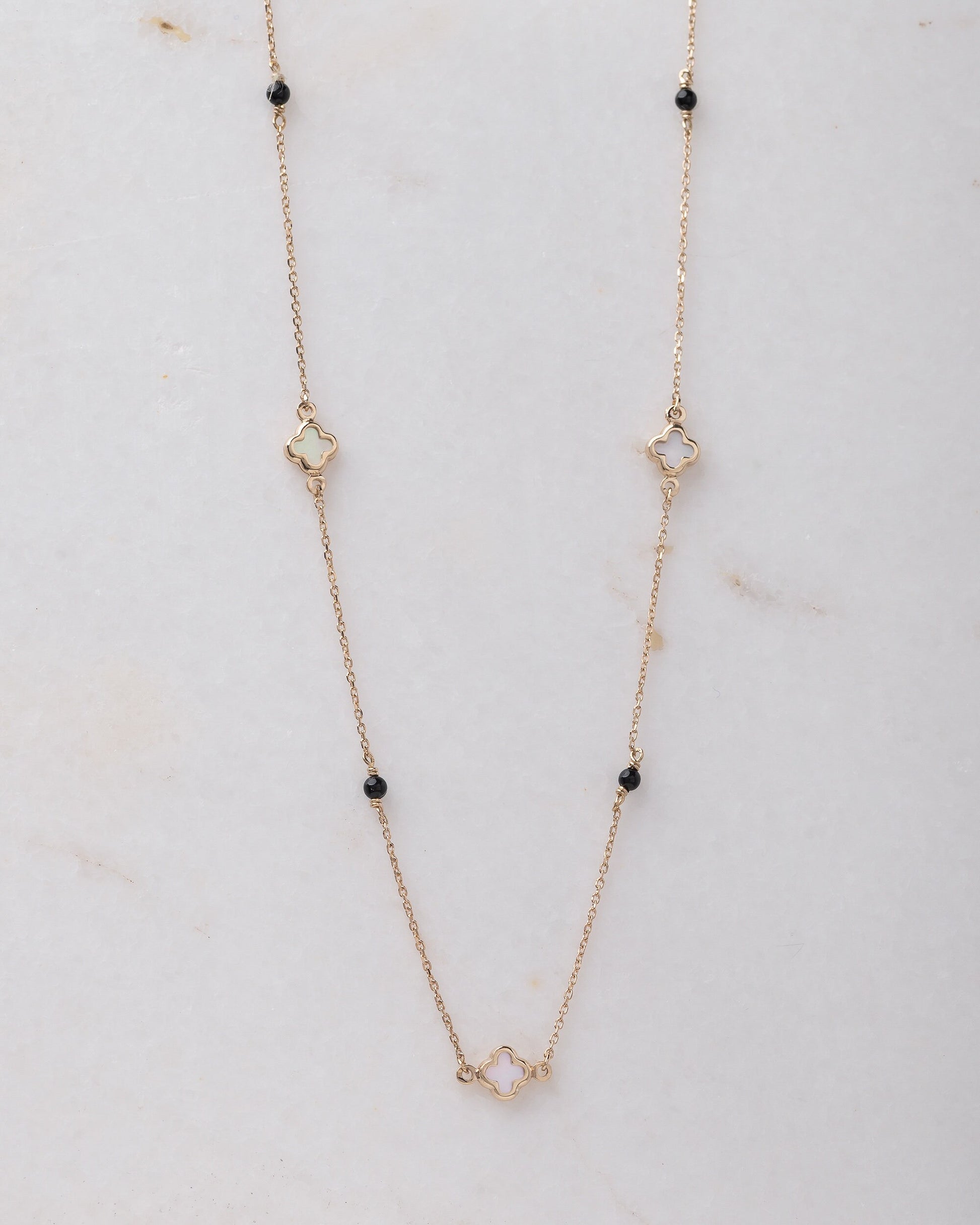 Mother-of-pearl clover necklace with onyx beads in 14k gold.