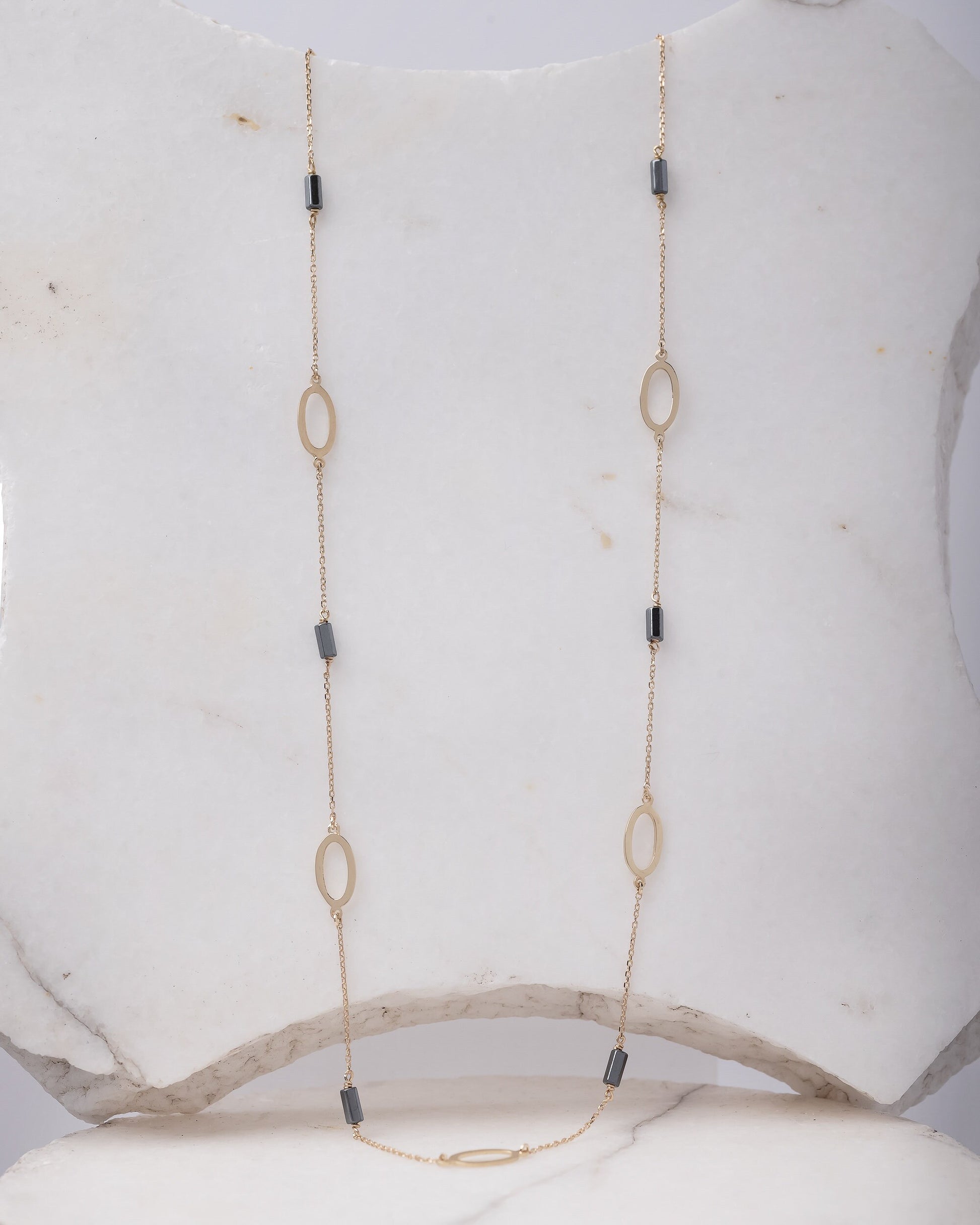 A station necklace adorned with oval patterns and bloodstone beads, crafted in 14k gold for women.