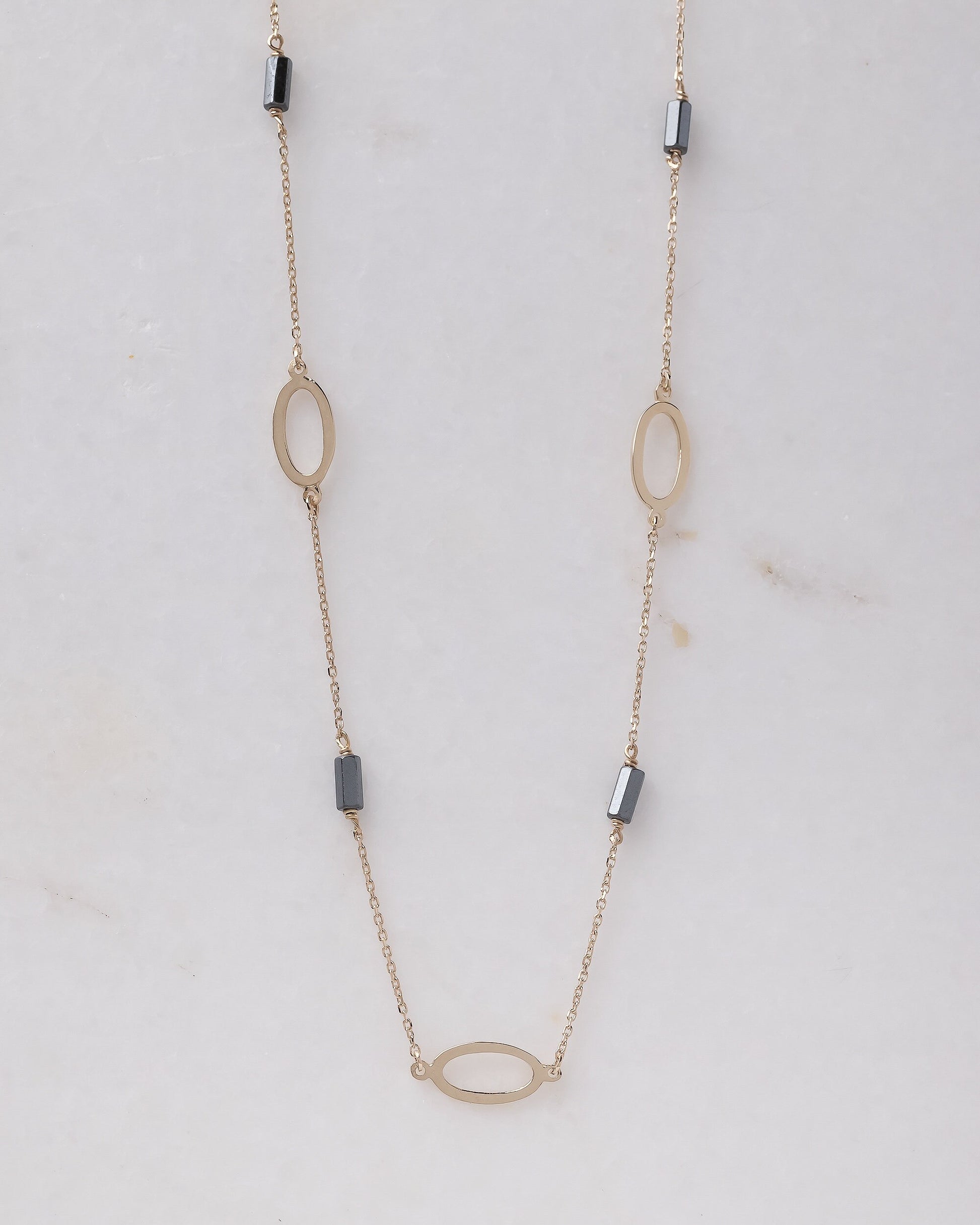 A station necklace adorned with oval patterns and bloodstone beads, crafted in 14k gold for women.