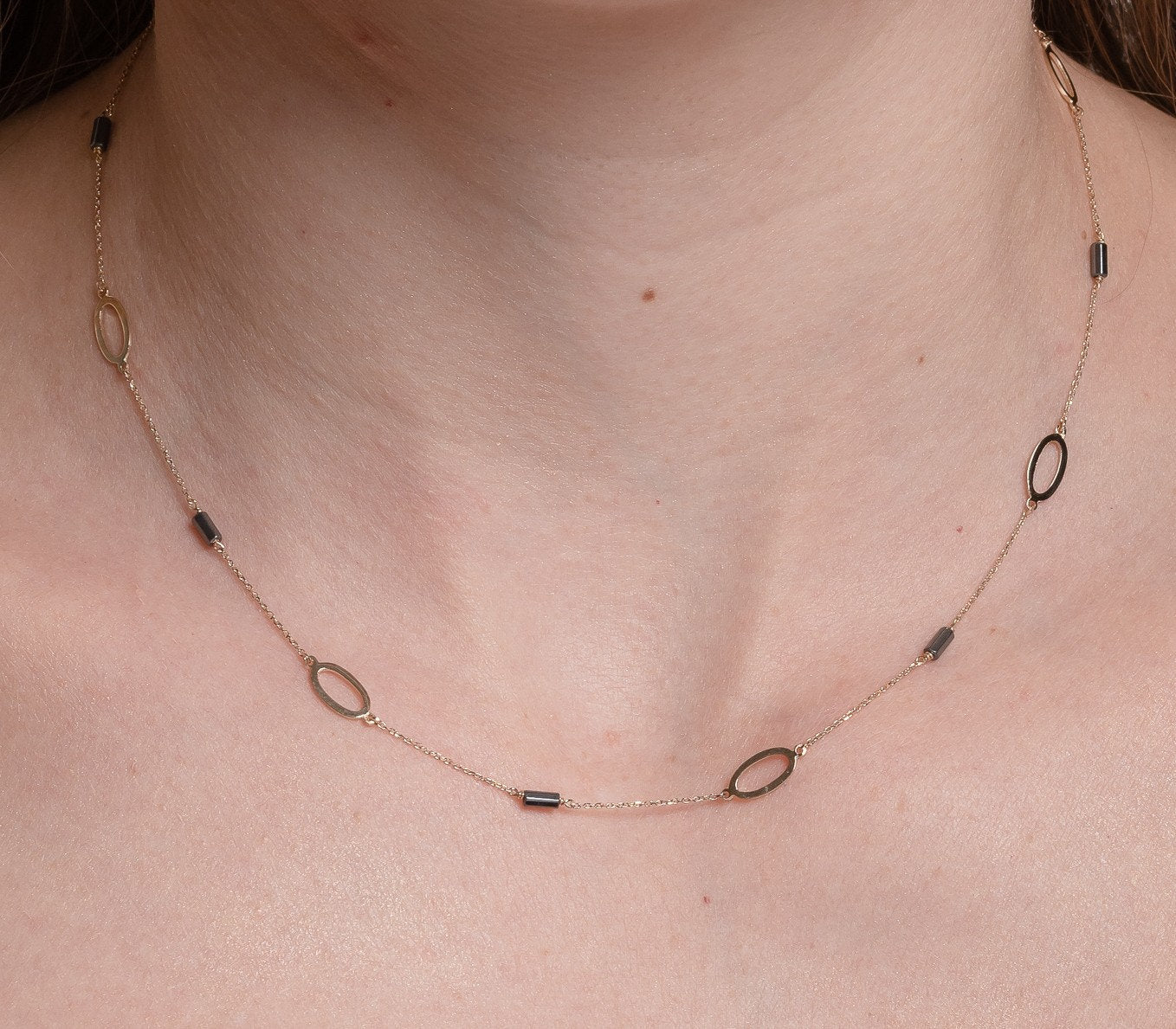 A station necklace adorned with oval patterns and bloodstone beads, crafted in 14k gold for women.