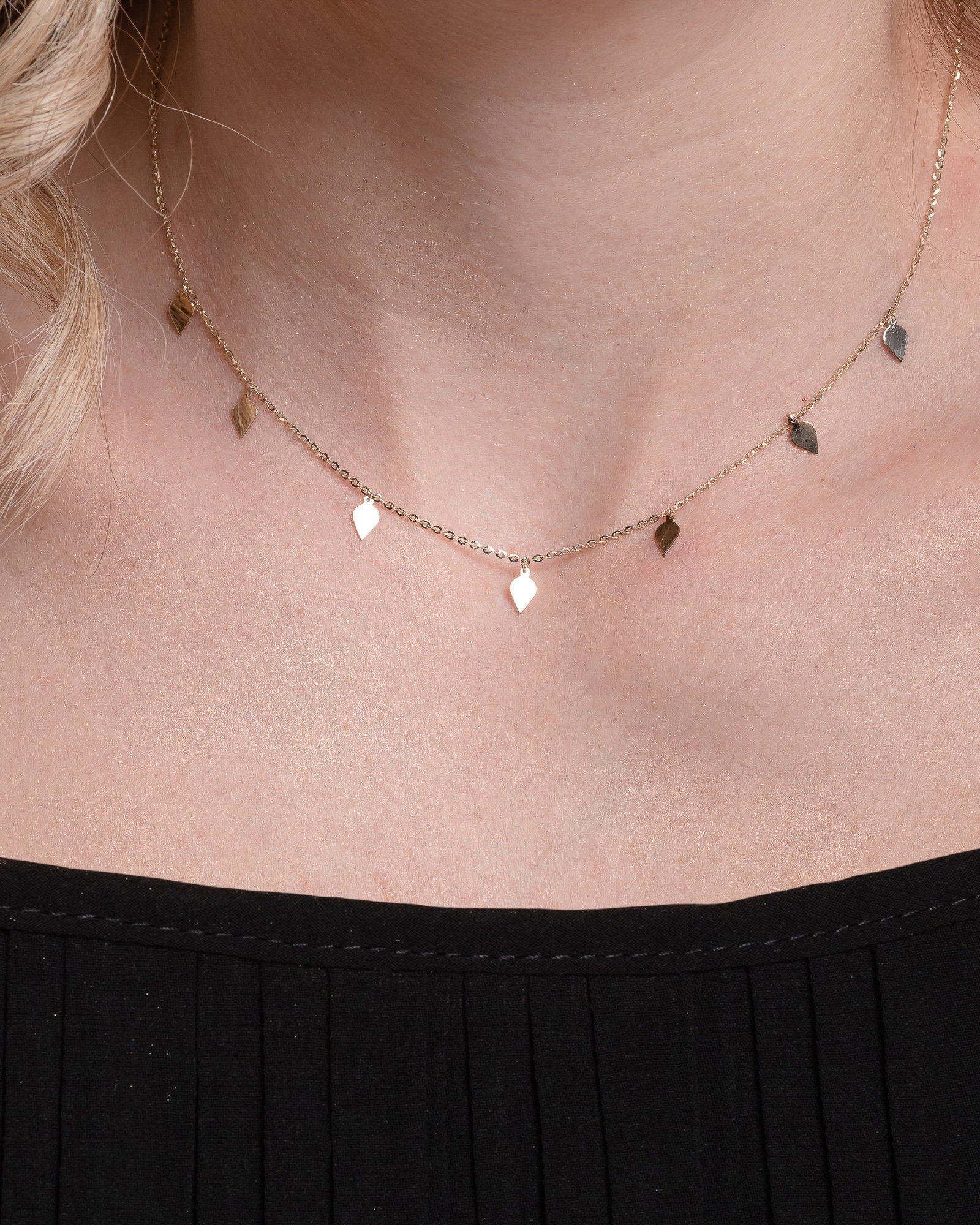 A station necklace featuring seven leaves crafted in 14k yellow gold for women.