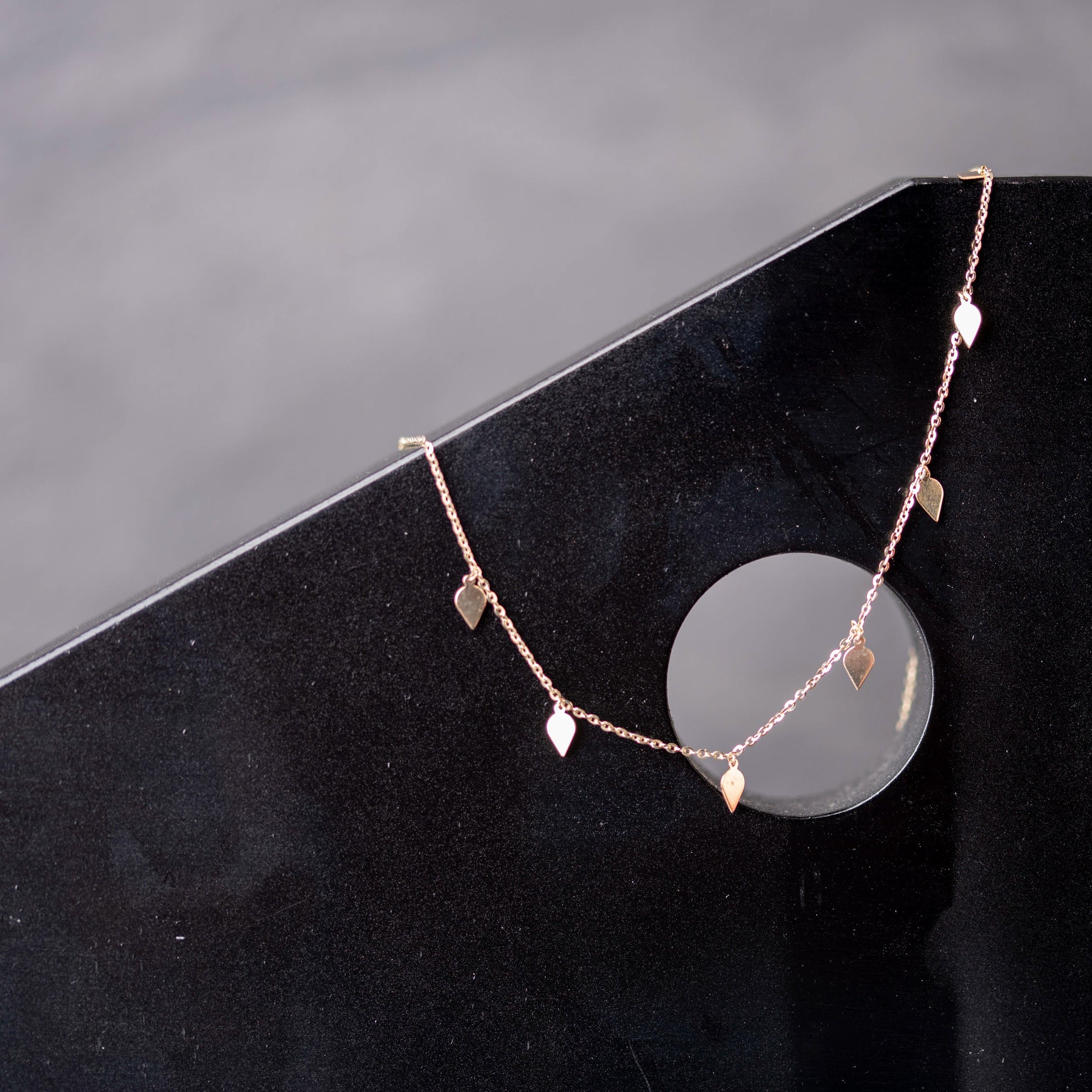 A station necklace featuring seven leaves crafted in 14k yellow gold for women.