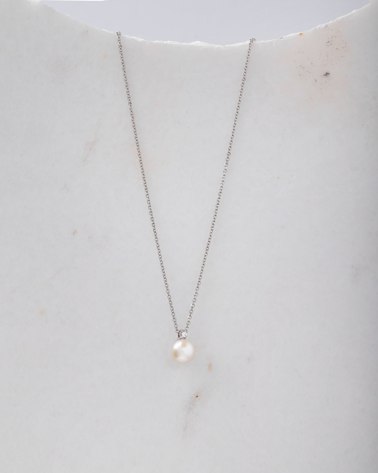 A diamond pearl necklace in 14k white gold for women.