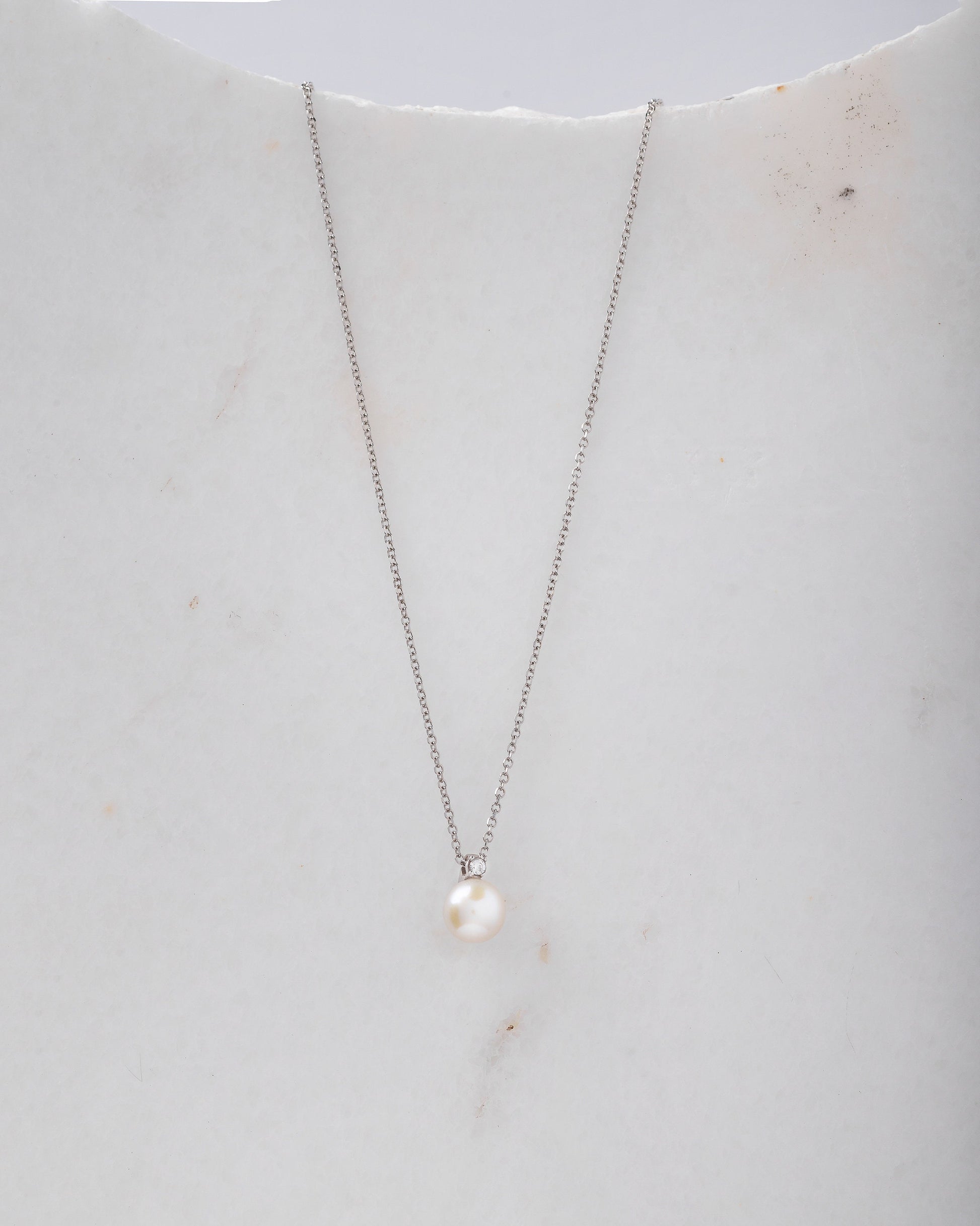 A diamond pearl necklace in 14k white gold for women.