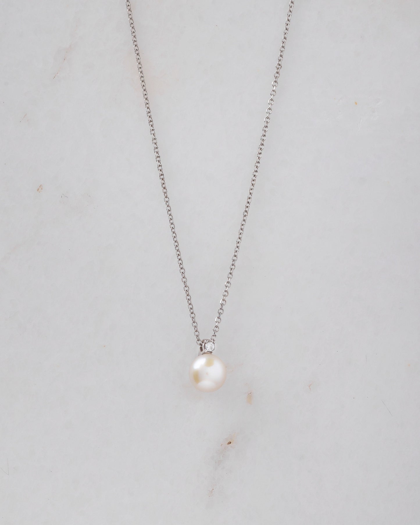 A diamond pearl necklace in 14k white gold for women.