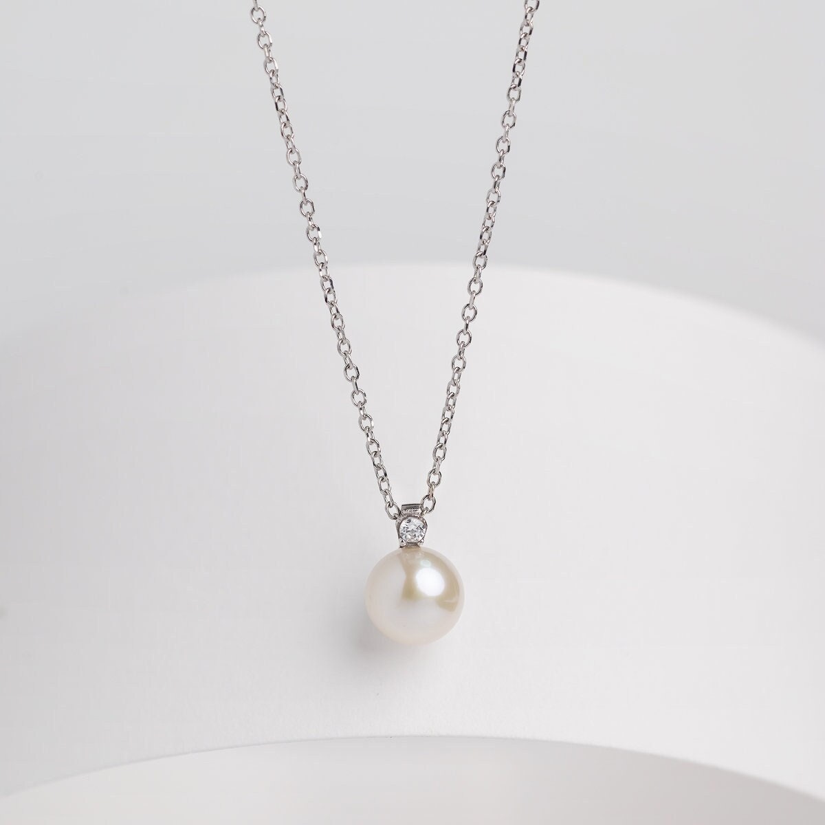 A diamond pearl necklace in 14k white gold for women.