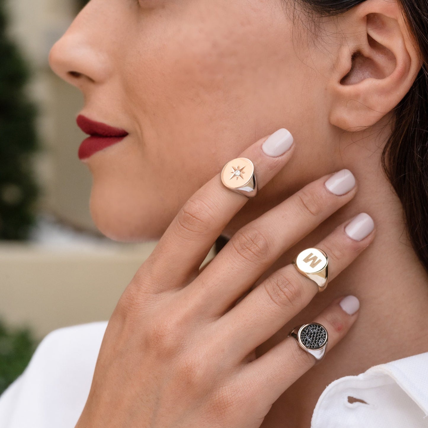 stylish collection of signet rings, featuring various designs worn by a model