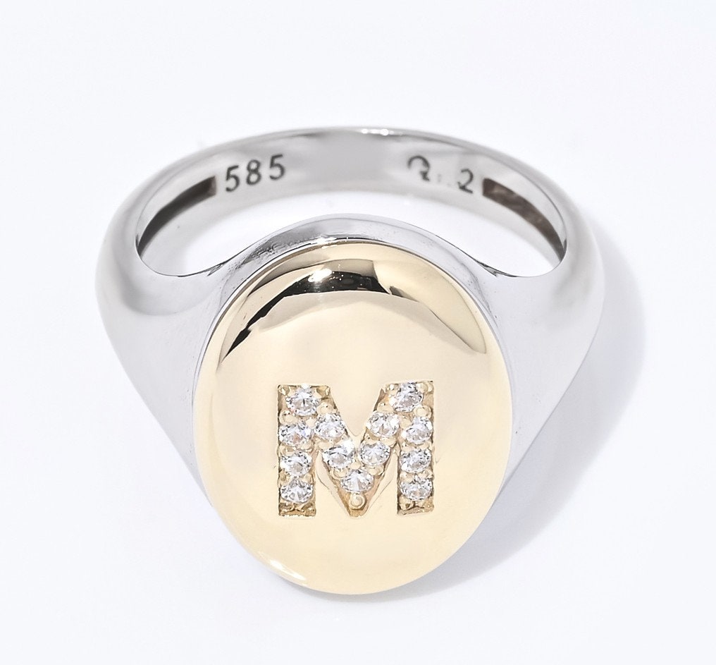 A two-tone monogrammed signet ring adorned with cubic zirconia stones, crafted in 14k gold for women.