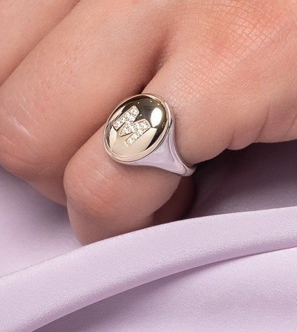 A two-tone monogrammed signet ring adorned with cubic zirconia stones, crafted in 14k gold for women.