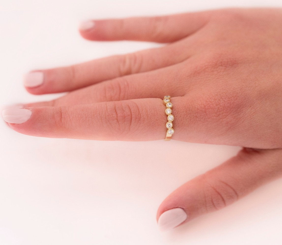 A half-eternity asymmetrical band crafted in 14k solid gold, adorned with white cubic zirconia stones.