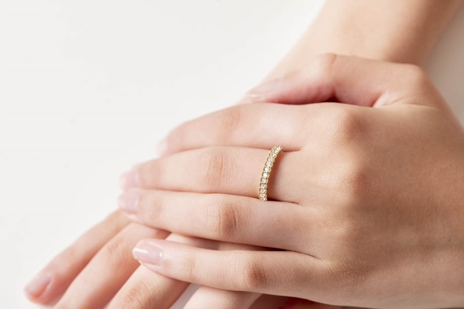 A women's half-eternity band ring featuring white cubic zirconia stones set in 14k gold.