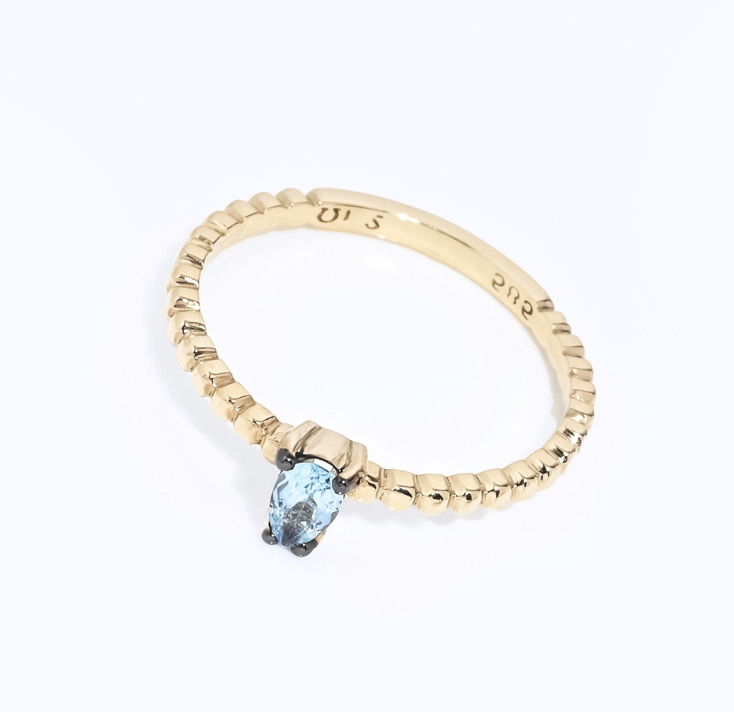 An aquamarine beaded ring in 14k gold, featuring a teardrop shape.