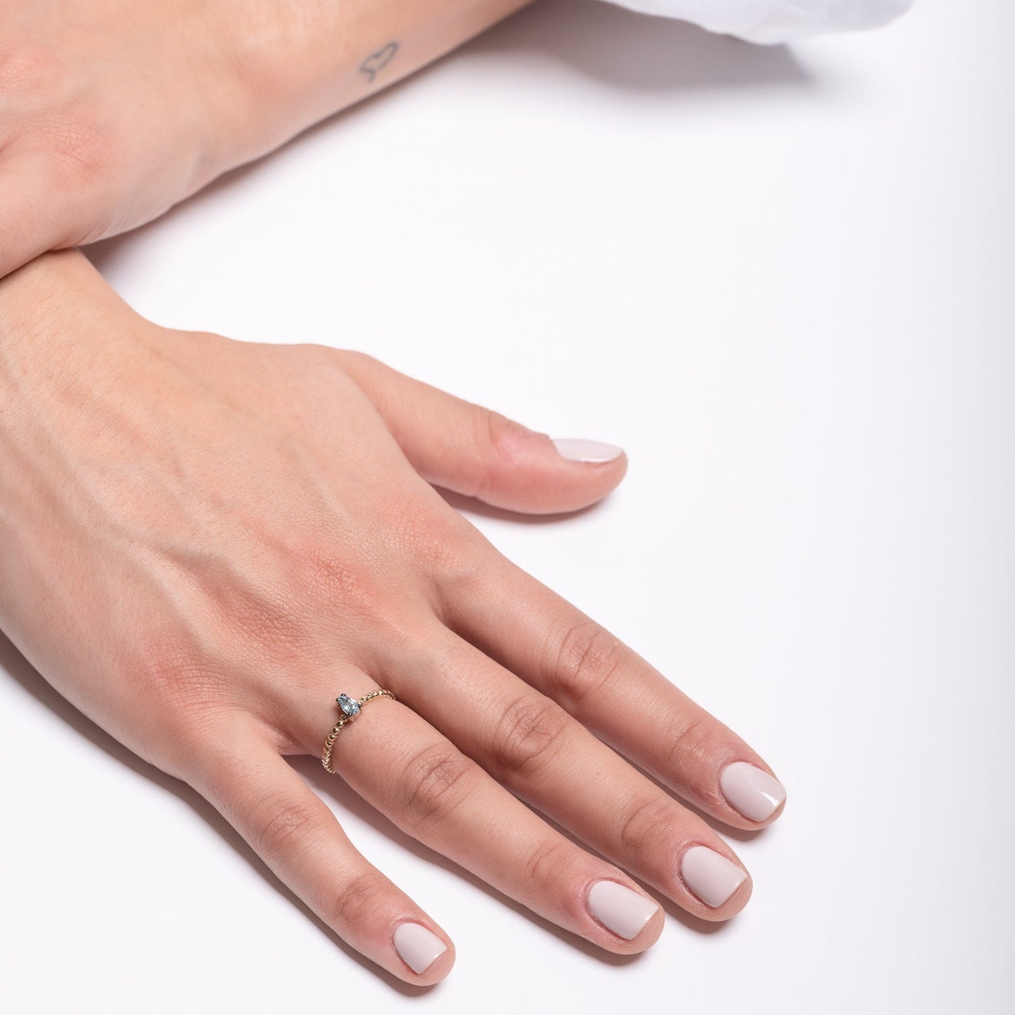 An aquamarine beaded ring in 14k gold, featuring a teardrop shape.