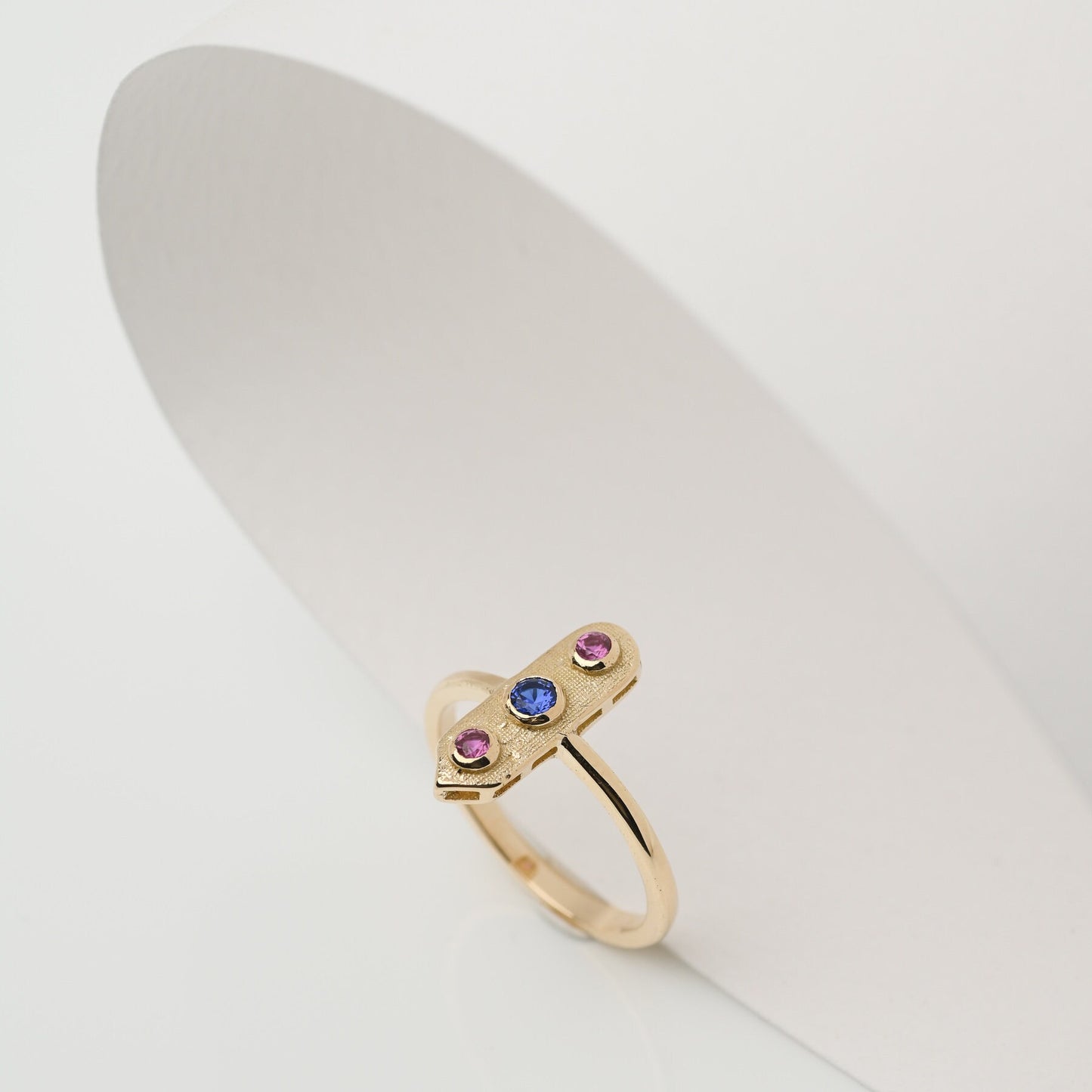 Handcrafted arrow-shaped gold ring with three gemstones set in 14k solid gold.