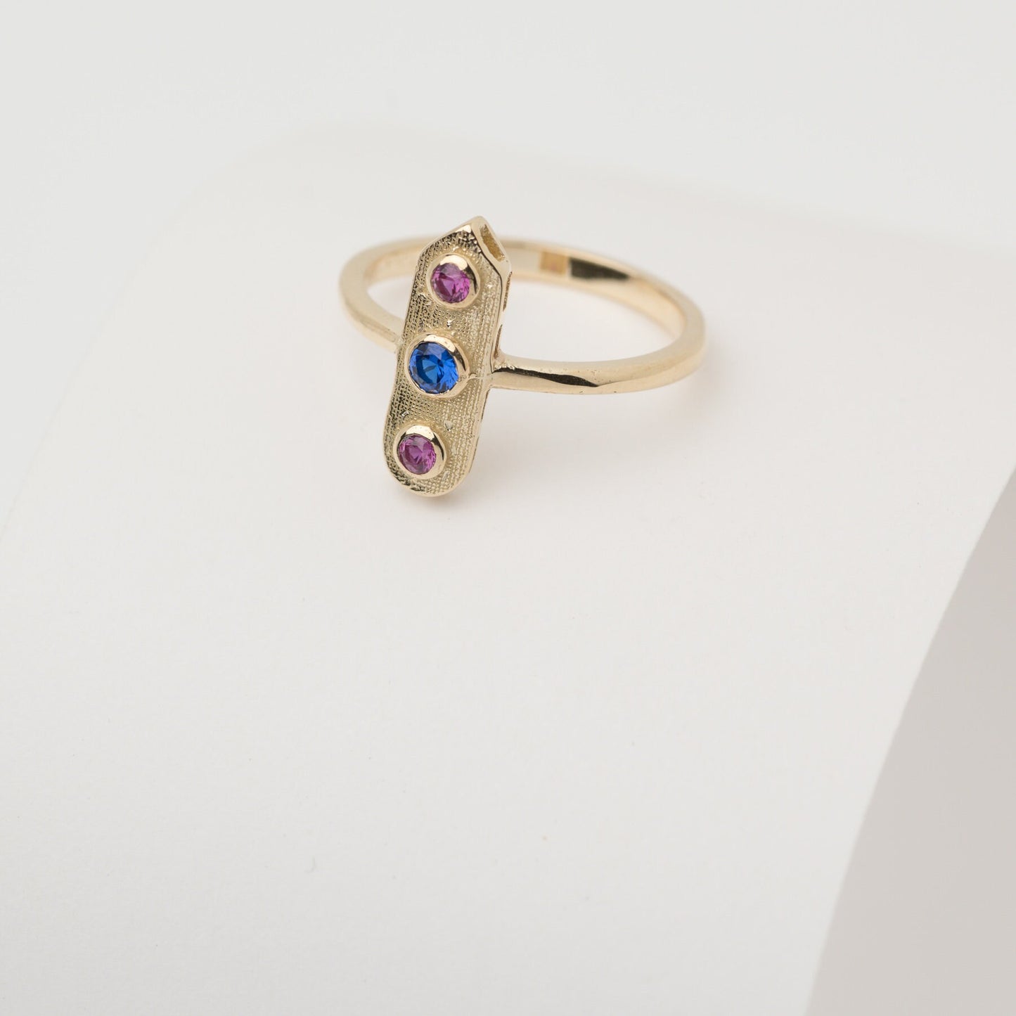 Handcrafted arrow-shaped gold ring with three gemstones set in 14k solid gold.