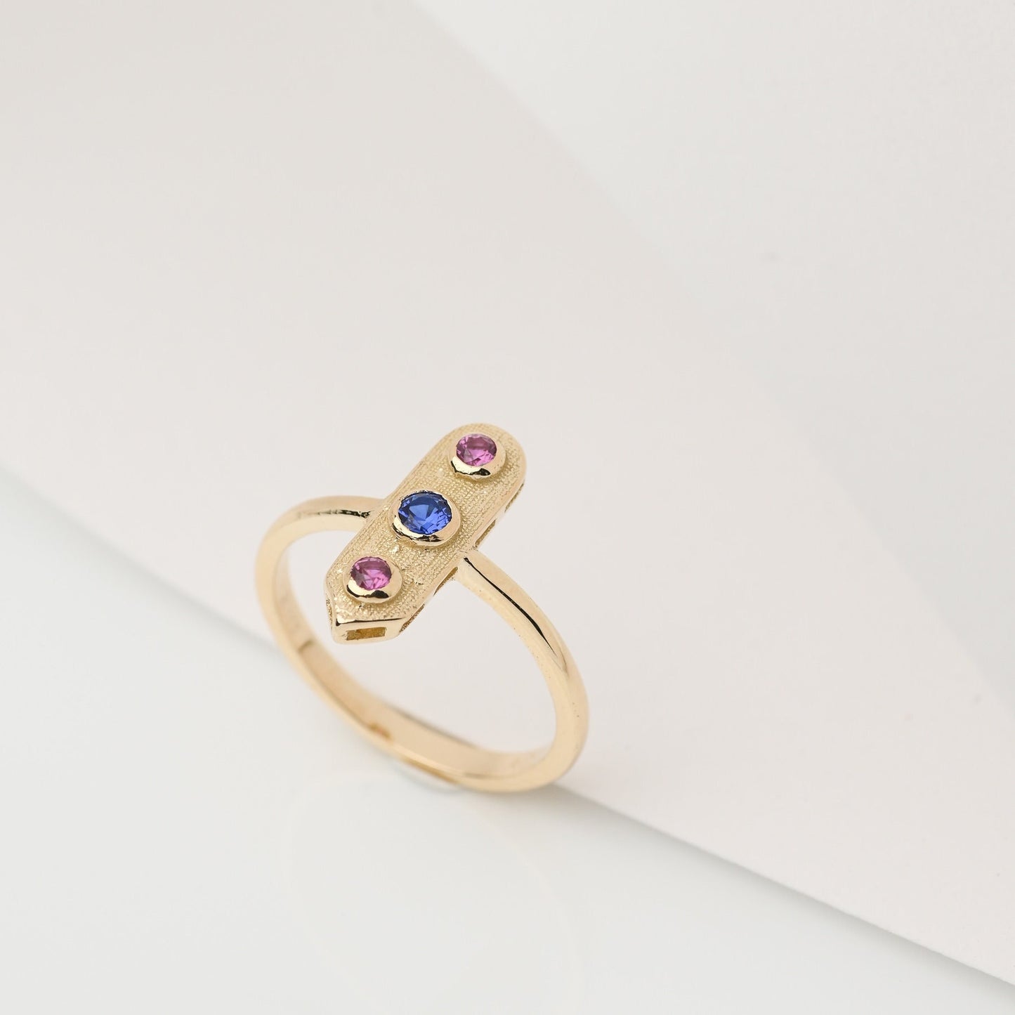 Handcrafted arrow-shaped gold ring with three gemstones set in 14k solid gold.