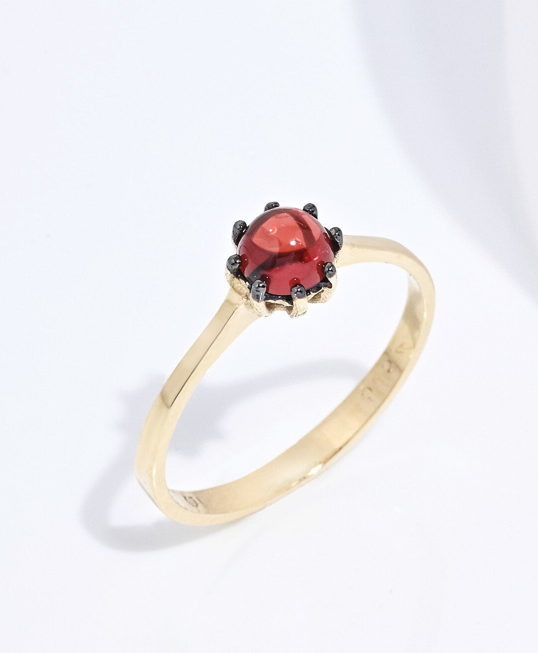 A natural garnet ring set in a 14k solid gold prong setting, designed for women.