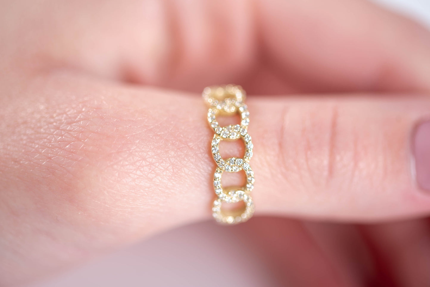 A handmade chain ring crafted in 14k solid gold, embellished with white cubic zirconia stones.