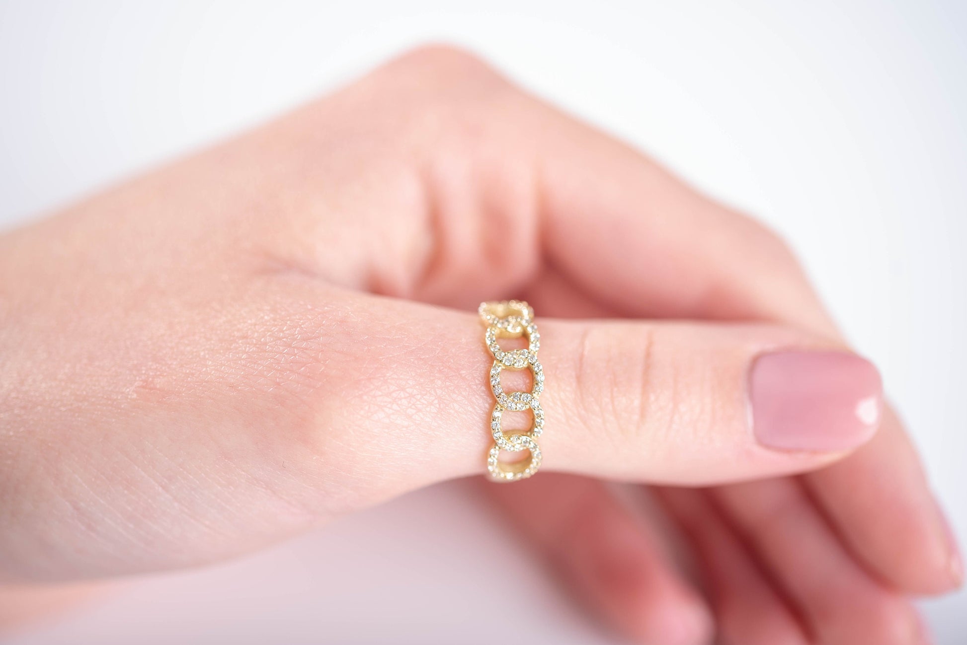 A handmade chain ring crafted in 14k solid gold, embellished with white cubic zirconia stones.