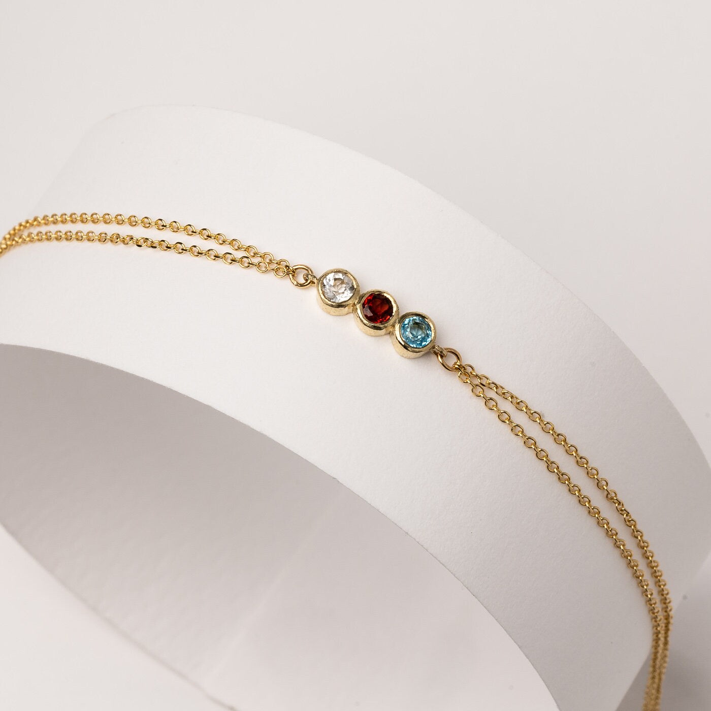 Handmade birthstone bracelet featuring three stones set in 14k gold, complemented by a double chain design for women.