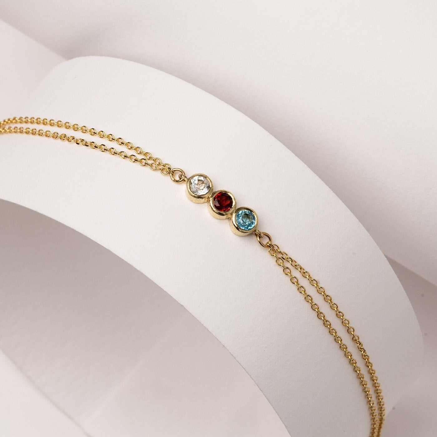 Handmade birthstone bracelet featuring three stones set in 14k gold, complemented by a double chain design for women.