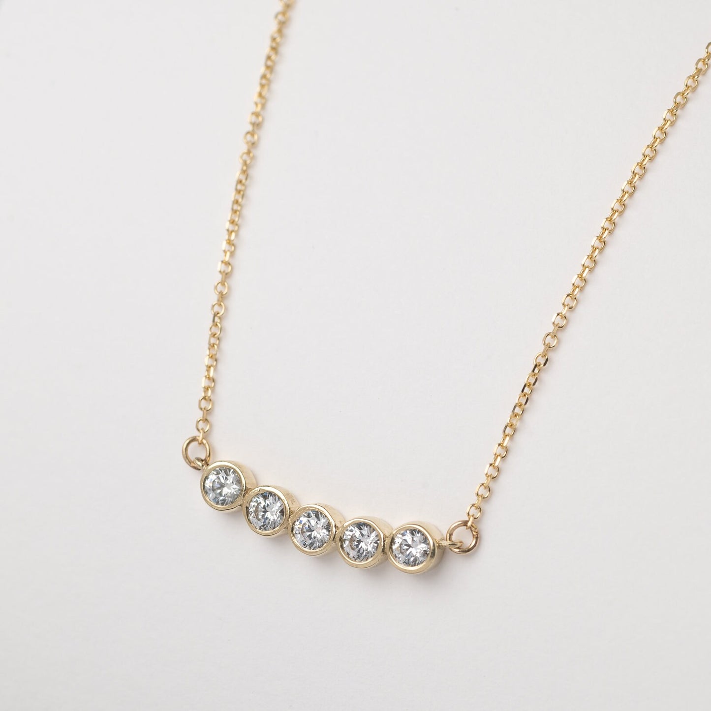 A 14k gold necklace for women, featuring five family birthstones.