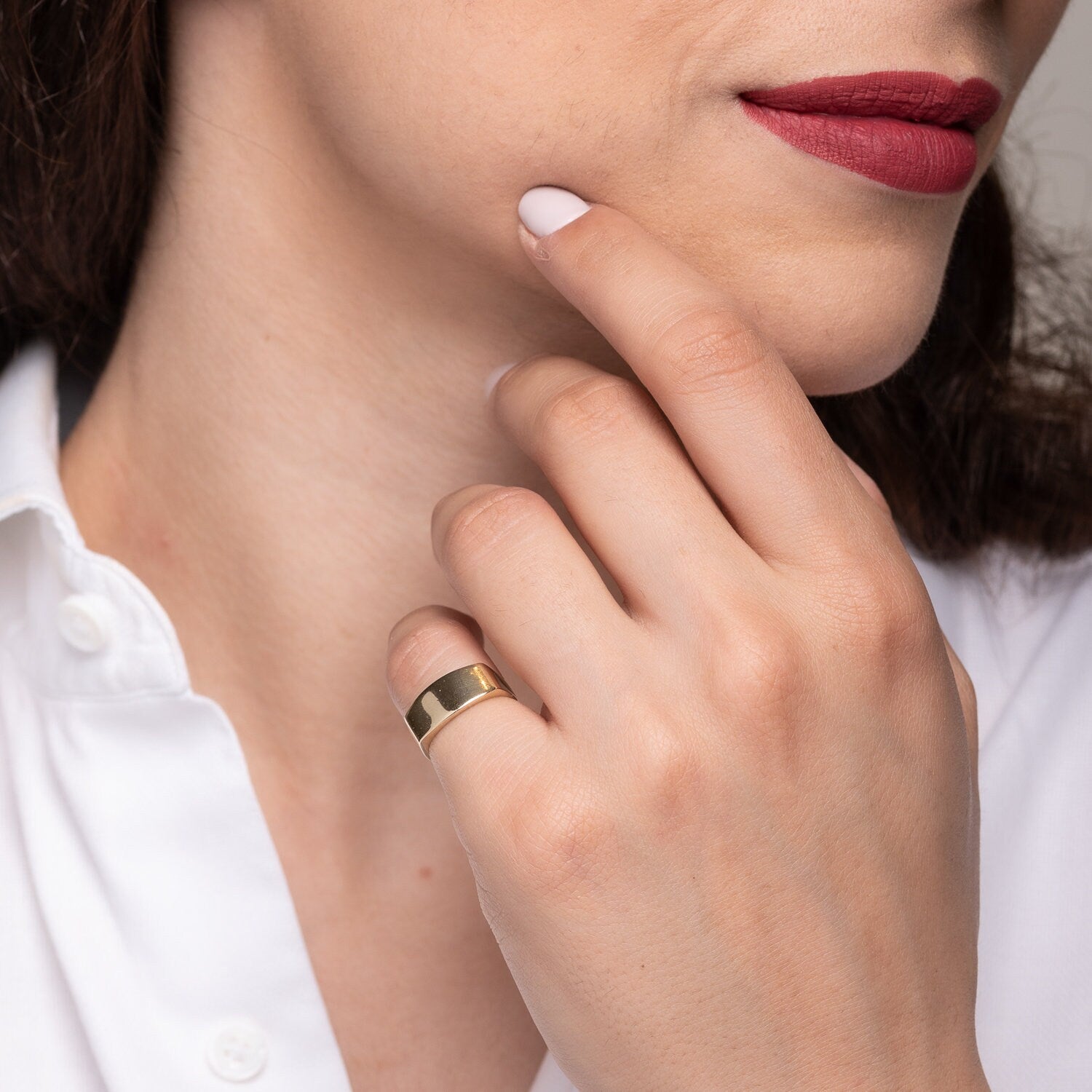 A personalized signet ring crafted in 14k gold, displayed on a model's pinky finger.