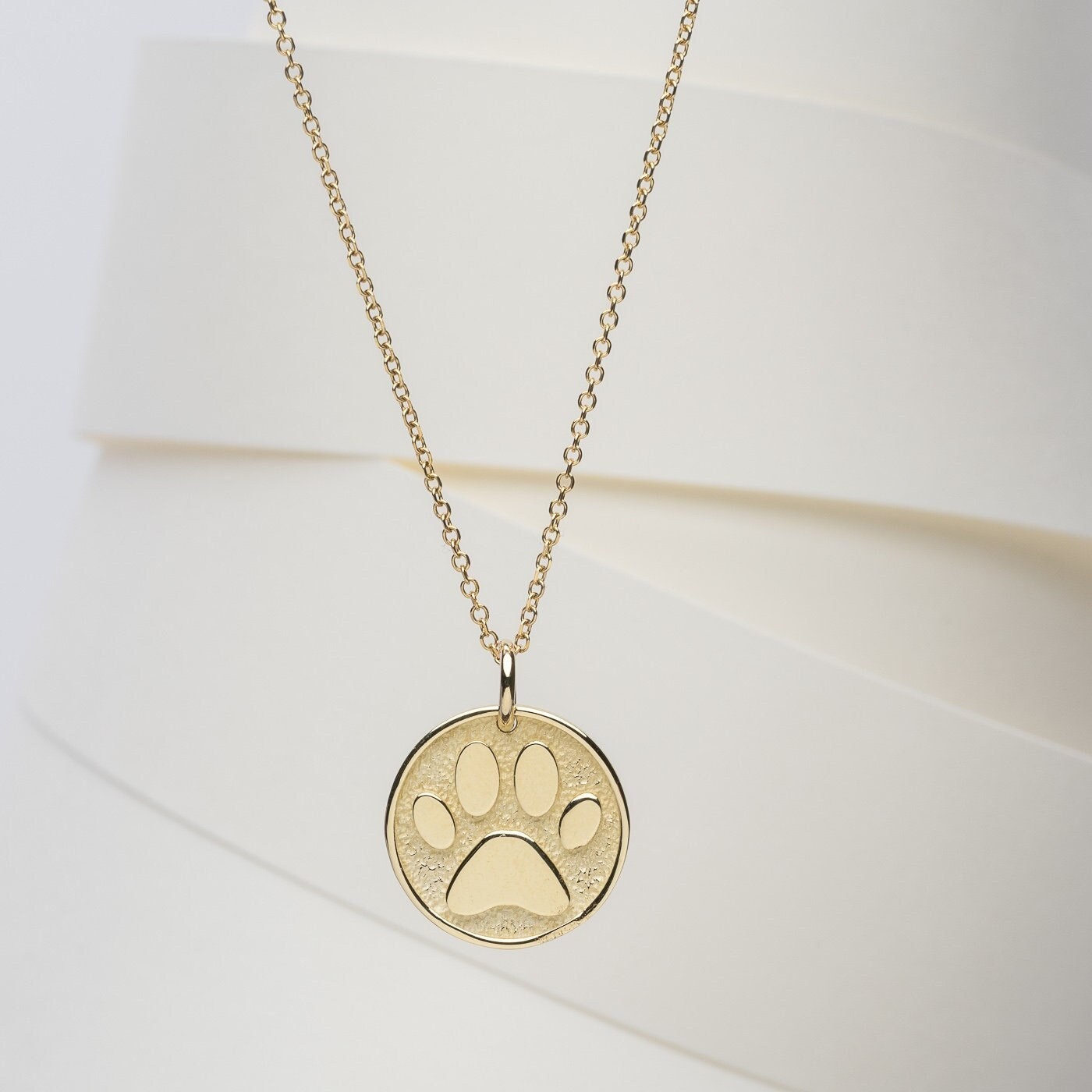 Paw Pendant crafted in 14k solid gold, complete with complimentary engraving on the reverse side.