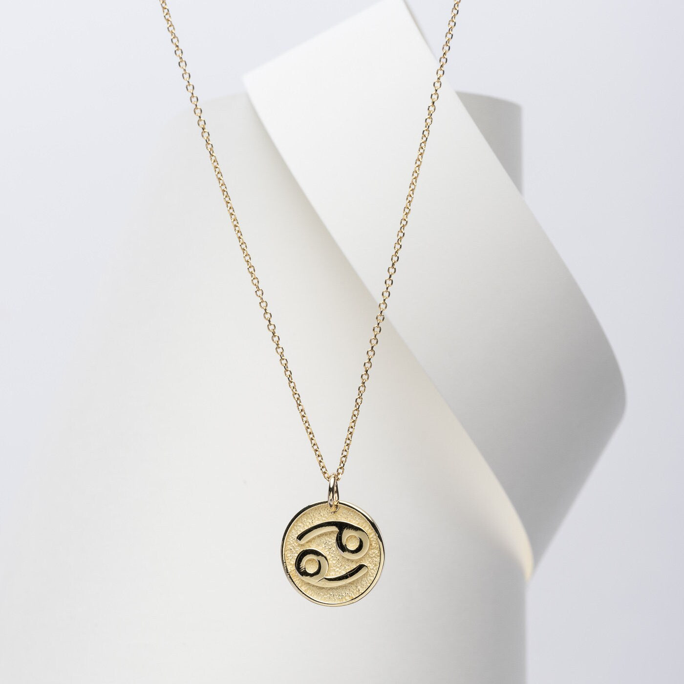 A Zodiac necklace for women, crafted in 14k gold, featuring complimentary engraving on the reverse side.