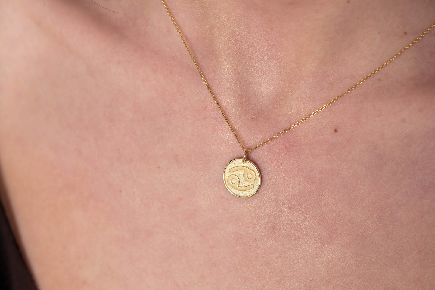 A Zodiac necklace for women, crafted in 14k gold, featuring complimentary engraving on the reverse side.